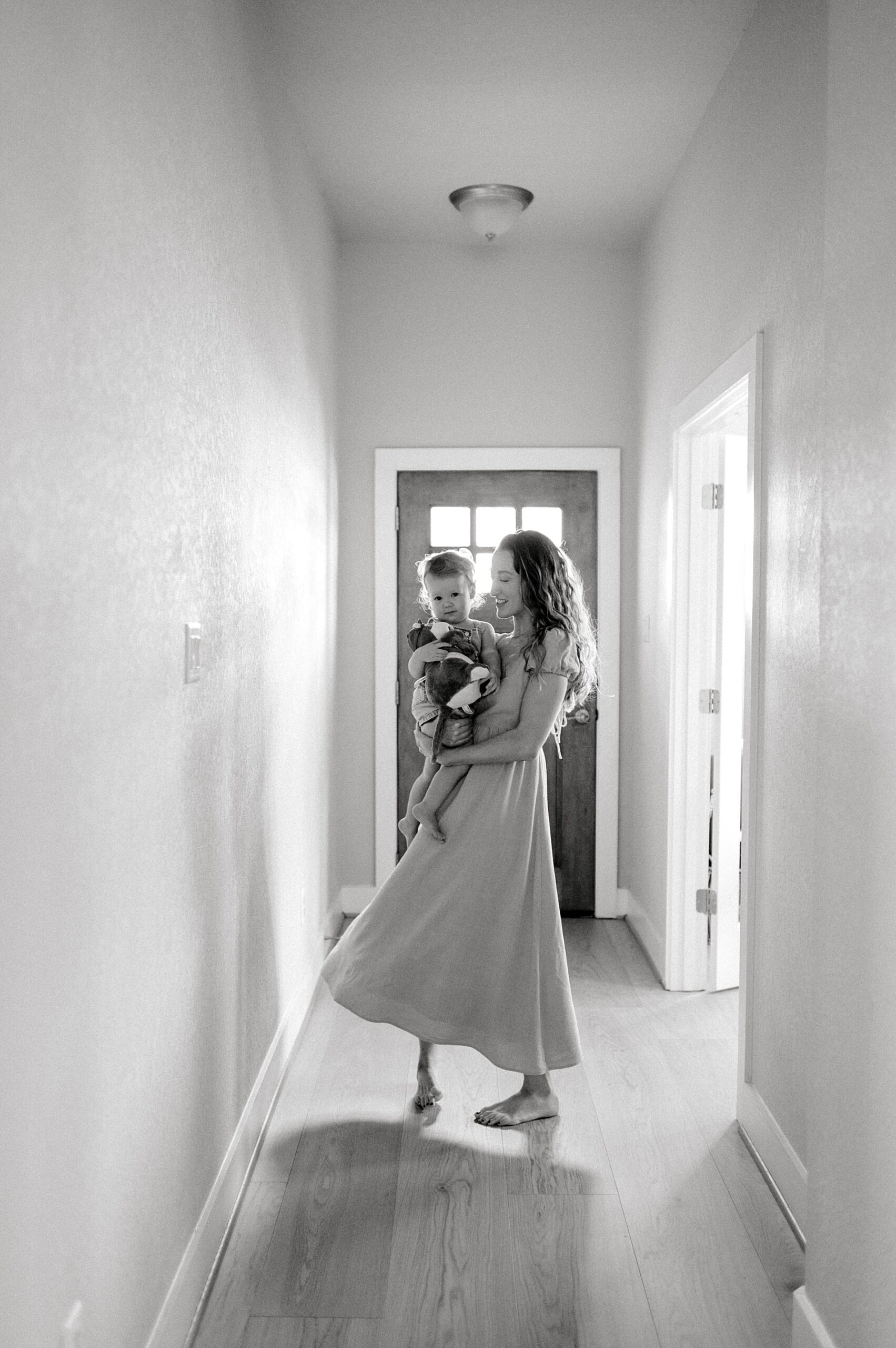 mom twirls in the hallway with her baby girl