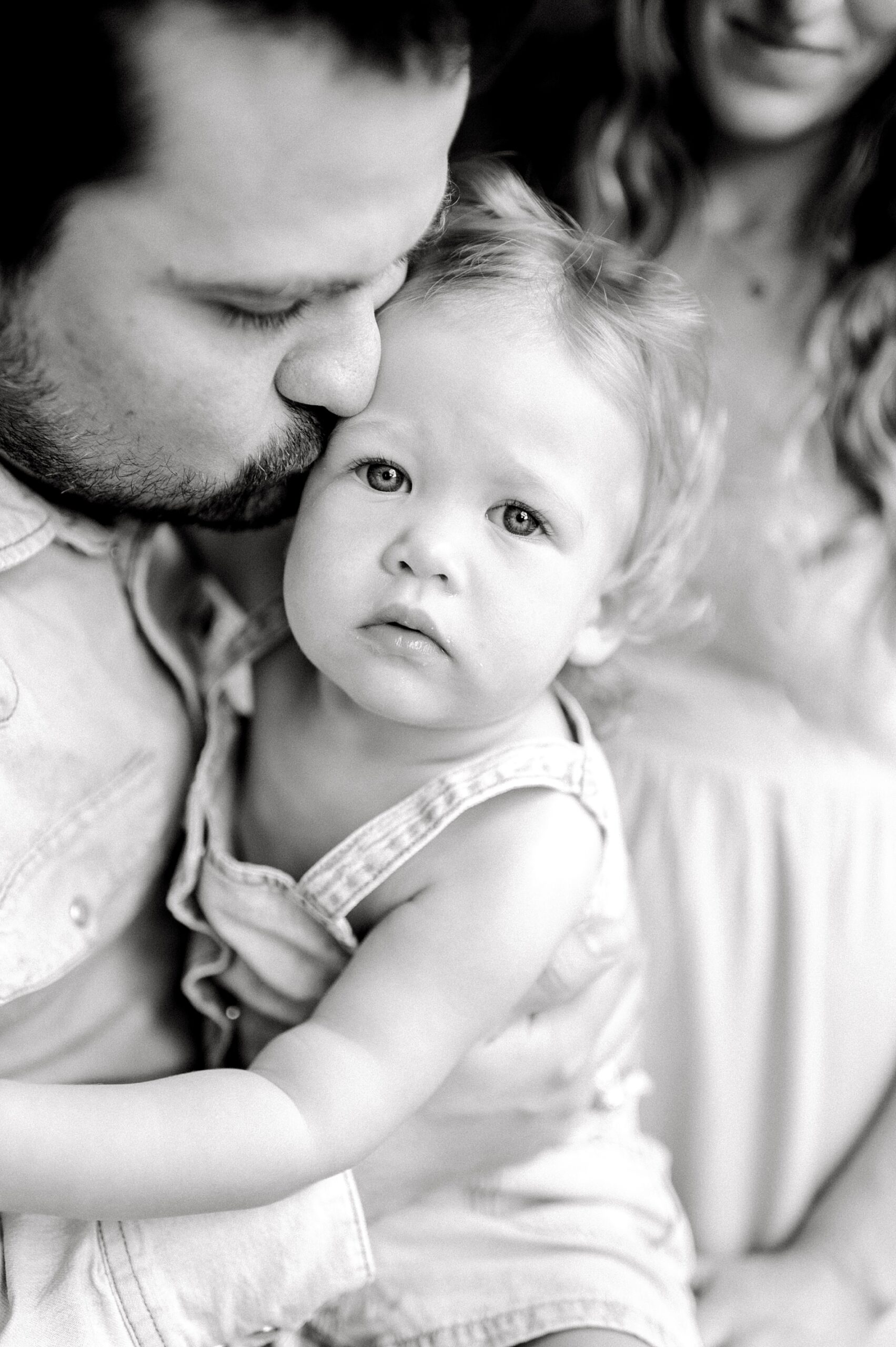 dad kisses his daughter's cheek