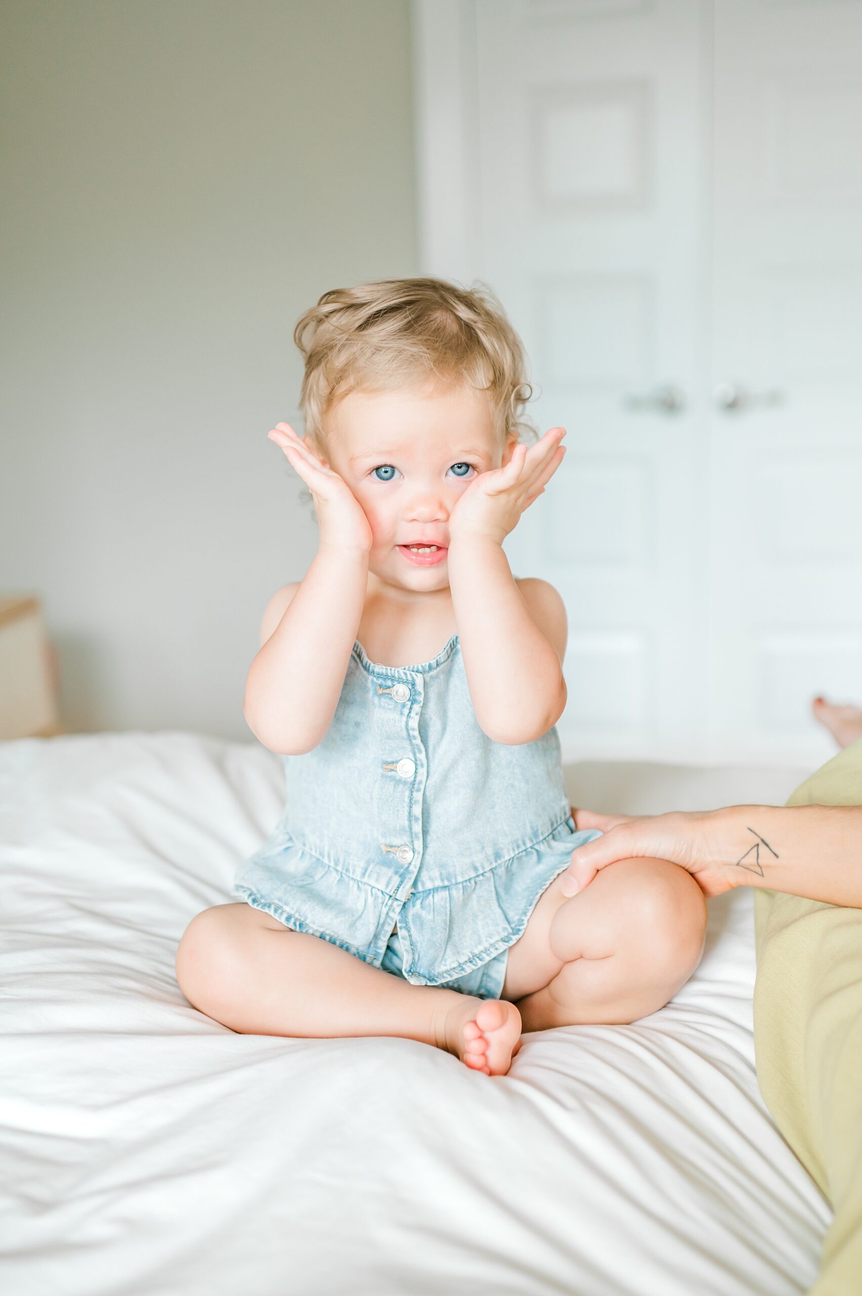 little girl plays peek-a-boo with camera 