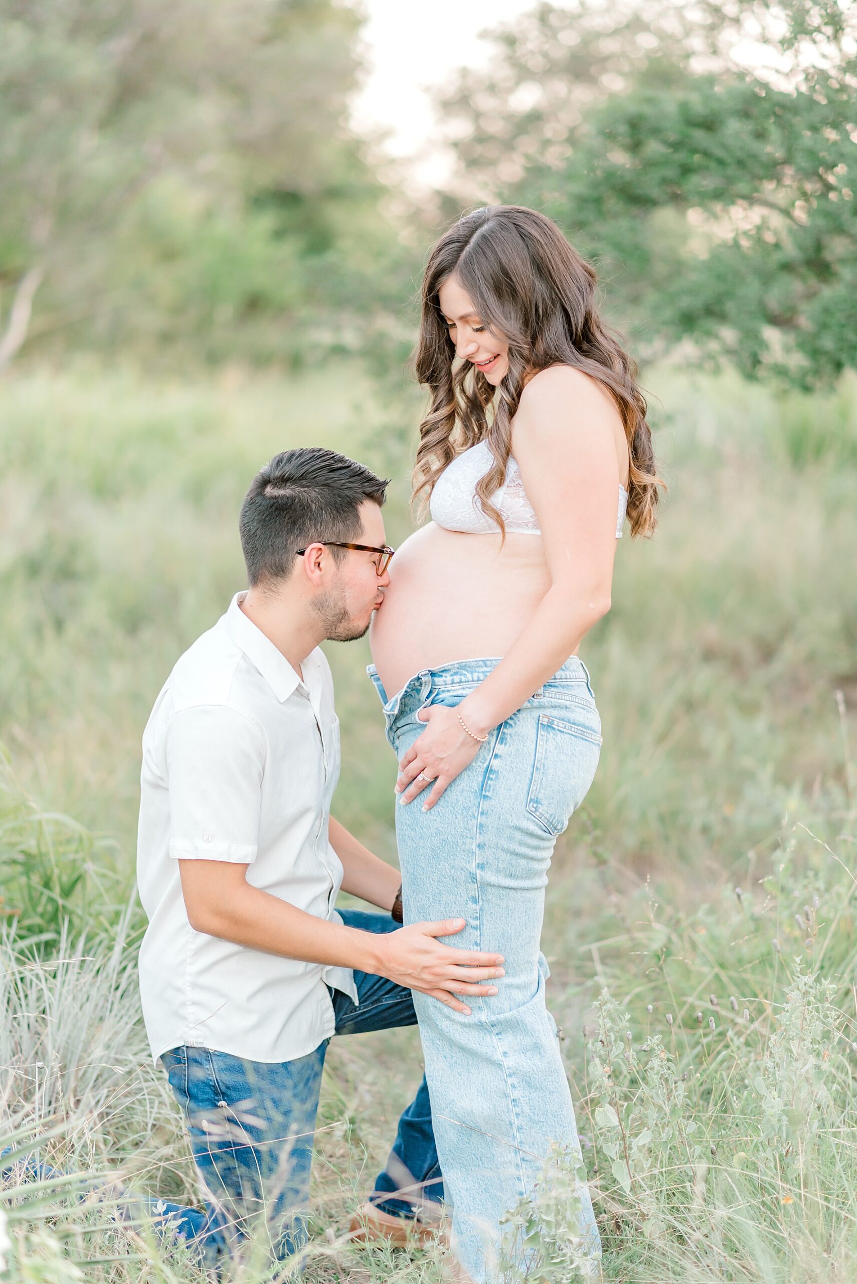 husband kisses wife's stomach during maternity session