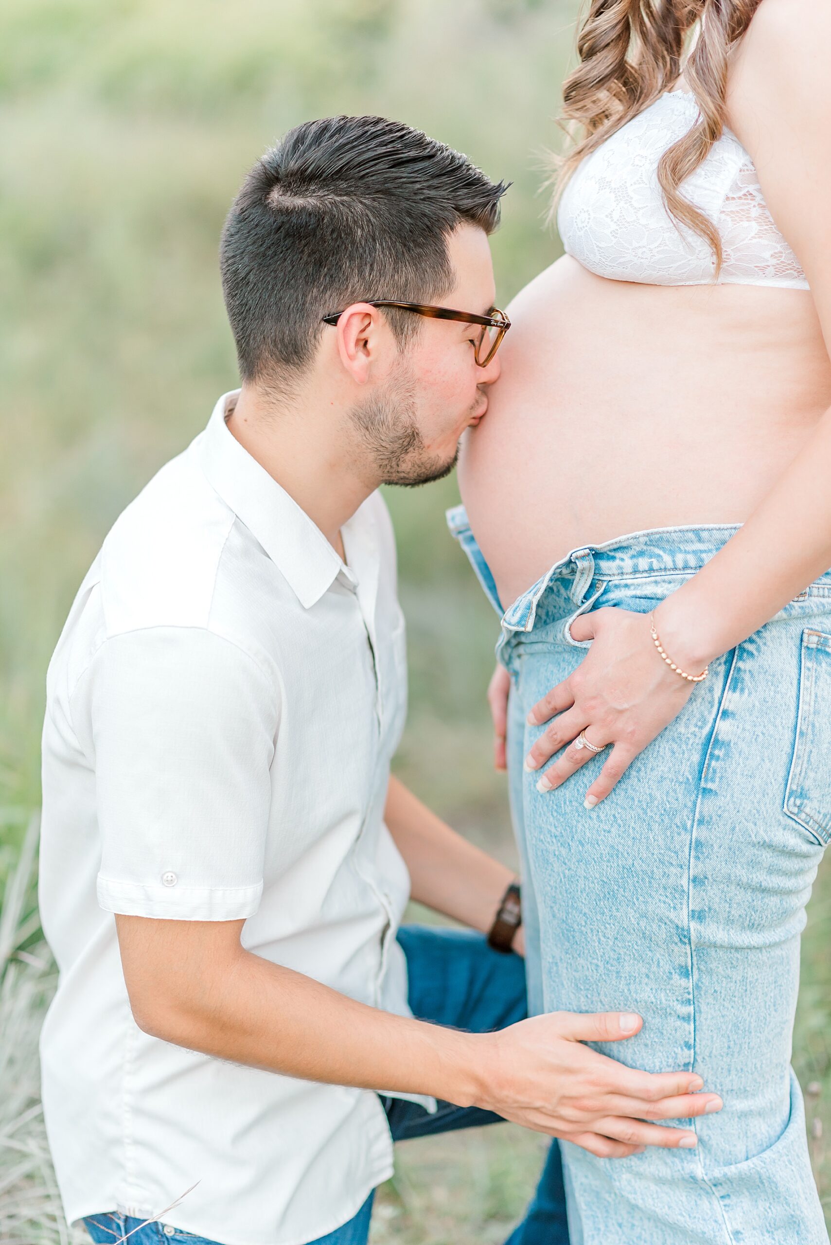 husband kisses wife's baby bump during Whimsical Maternity Session