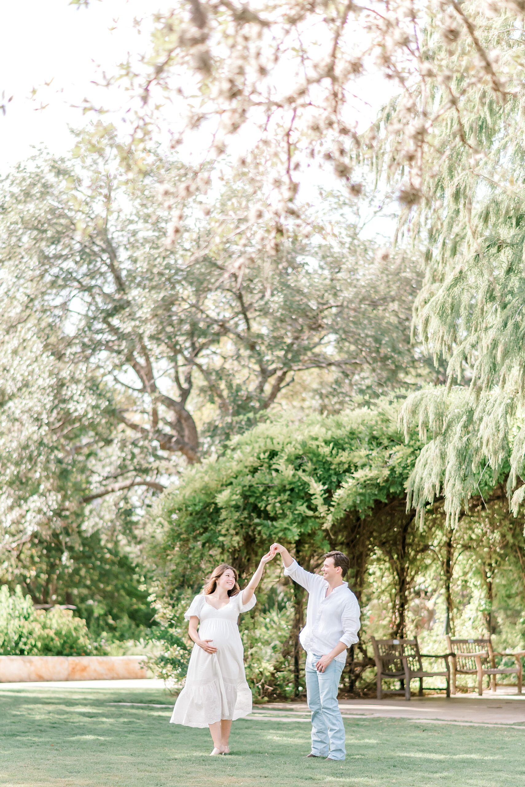 husband dances with his wife during Garden Maternity Session at San Antonio Botanical Gardens