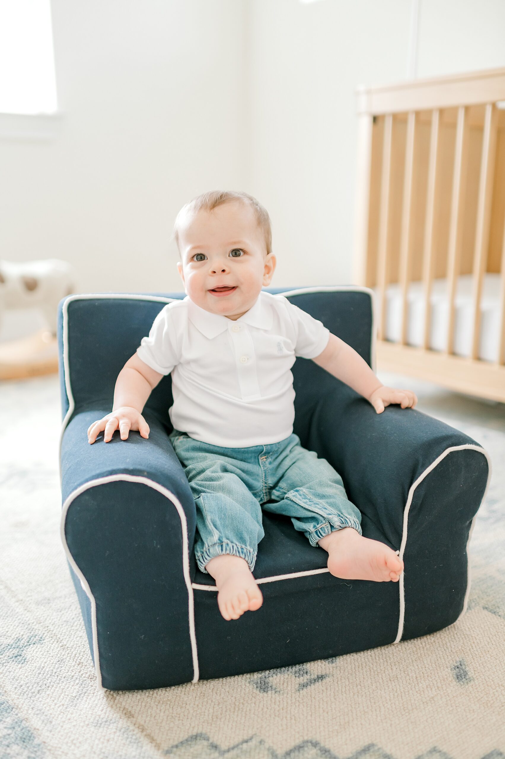 little boy sits in little chair during One-Year Milestone Session