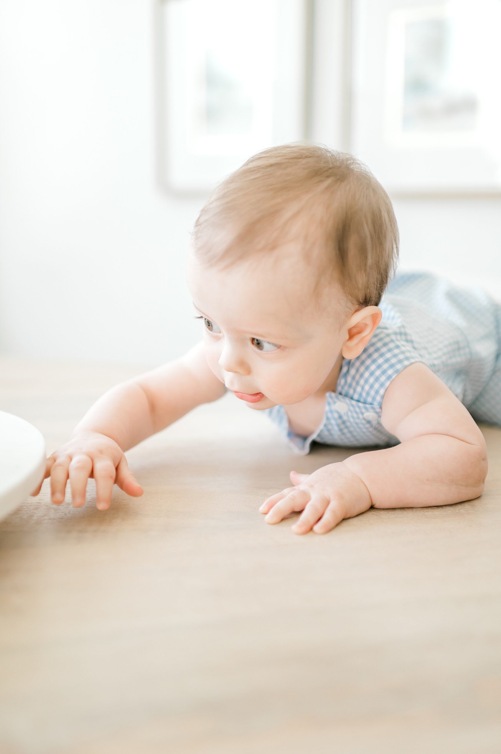 one-year old boy crawls on table