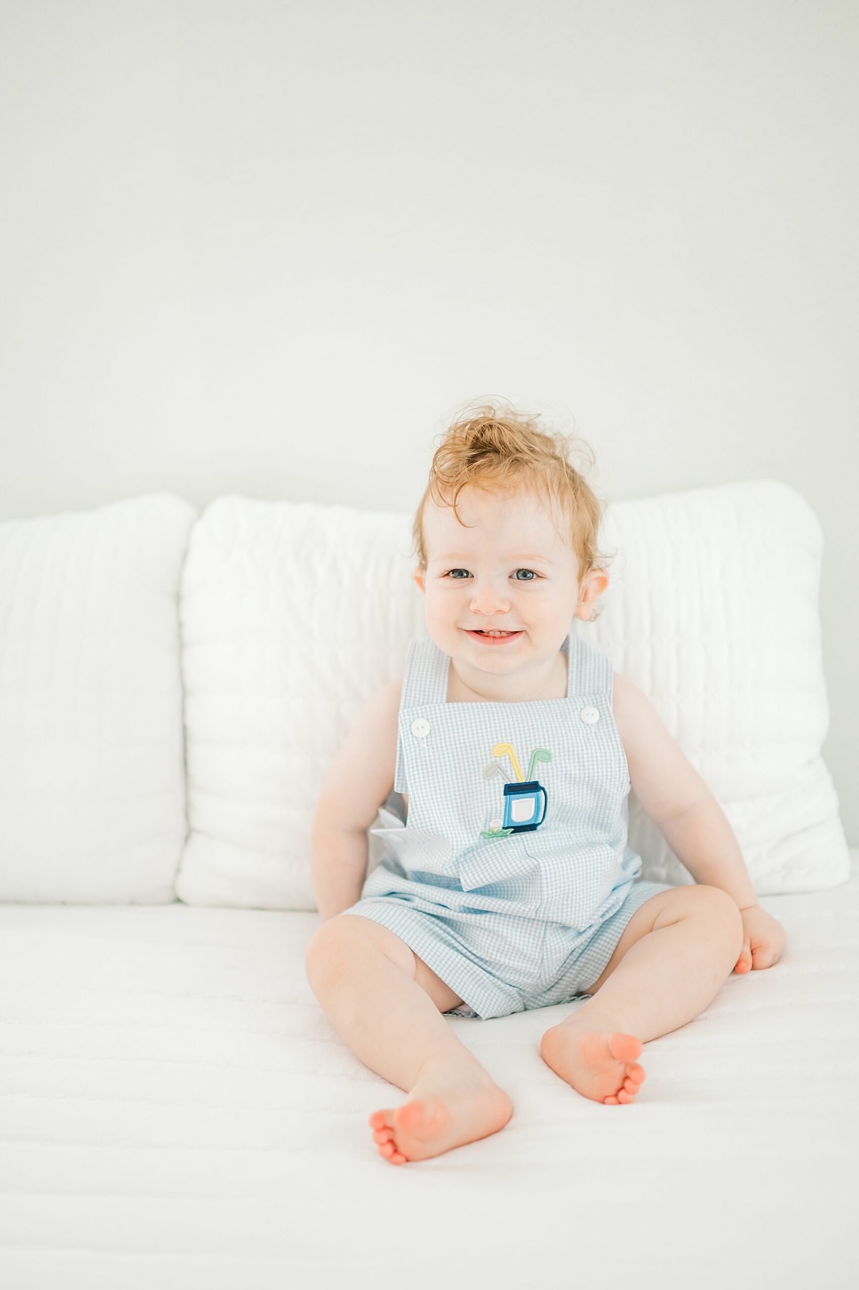 little boy sits on bed during One Year Milestone Studio Session