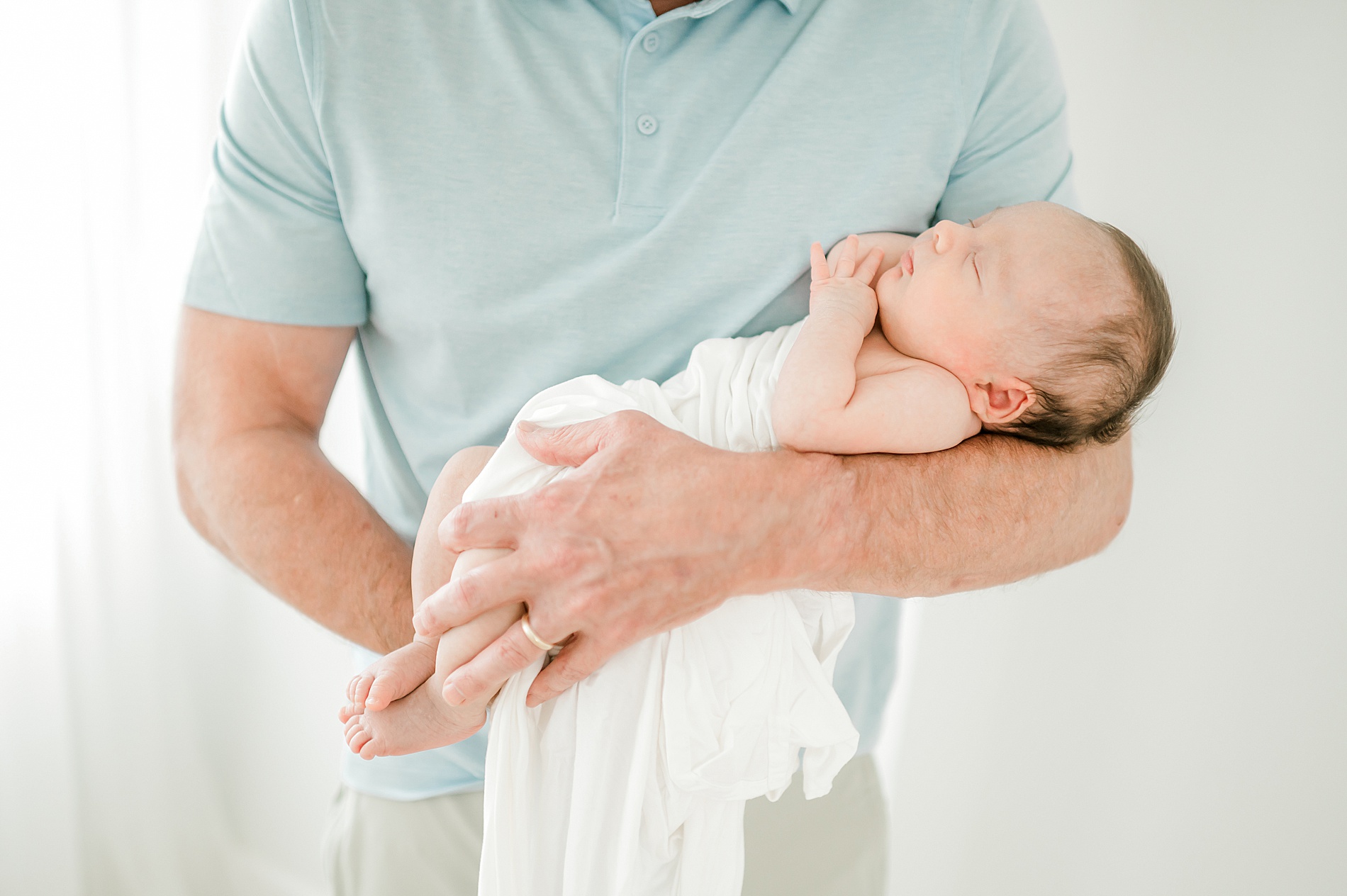 baby girl sleeps in dad's arms