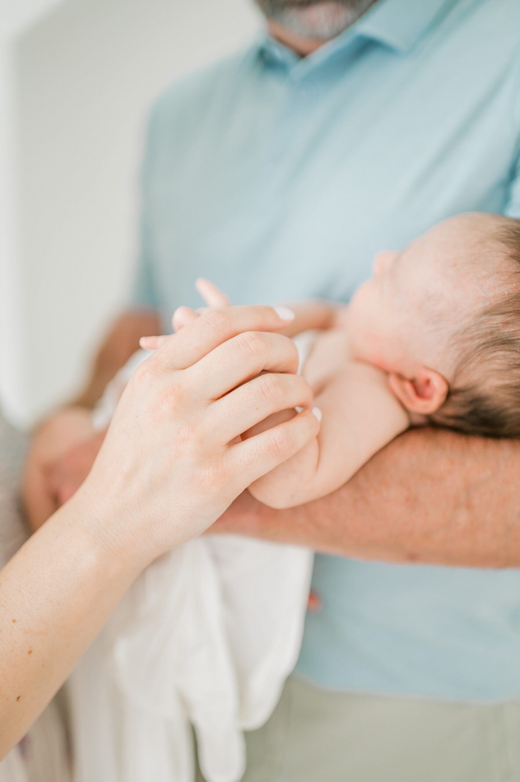 parents hold their baby girl in their arms