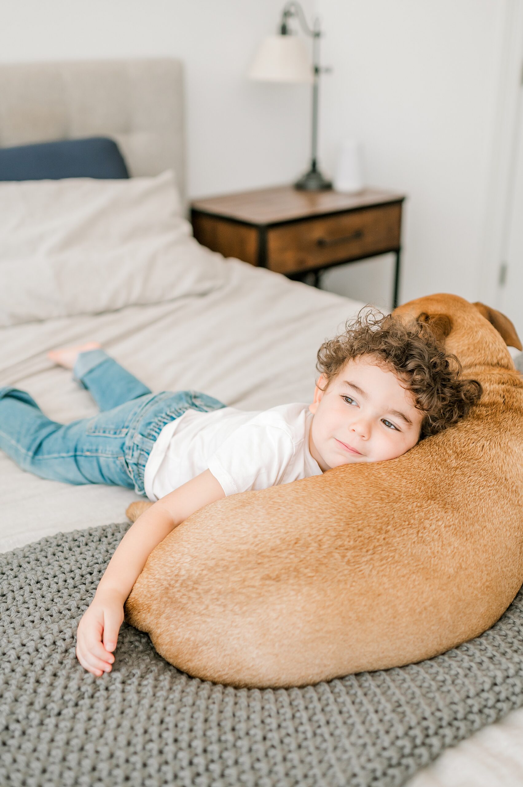 older brother lays with family dog