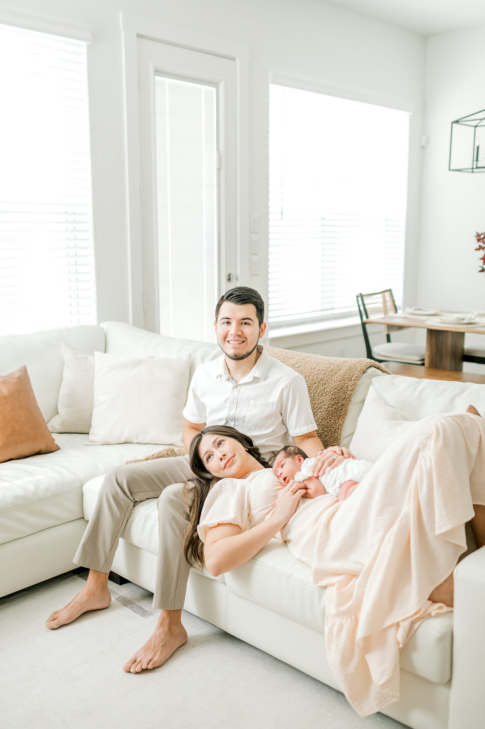 new family cuddles on family couch in living room | Choosing the Best Rooms for Natural Light 