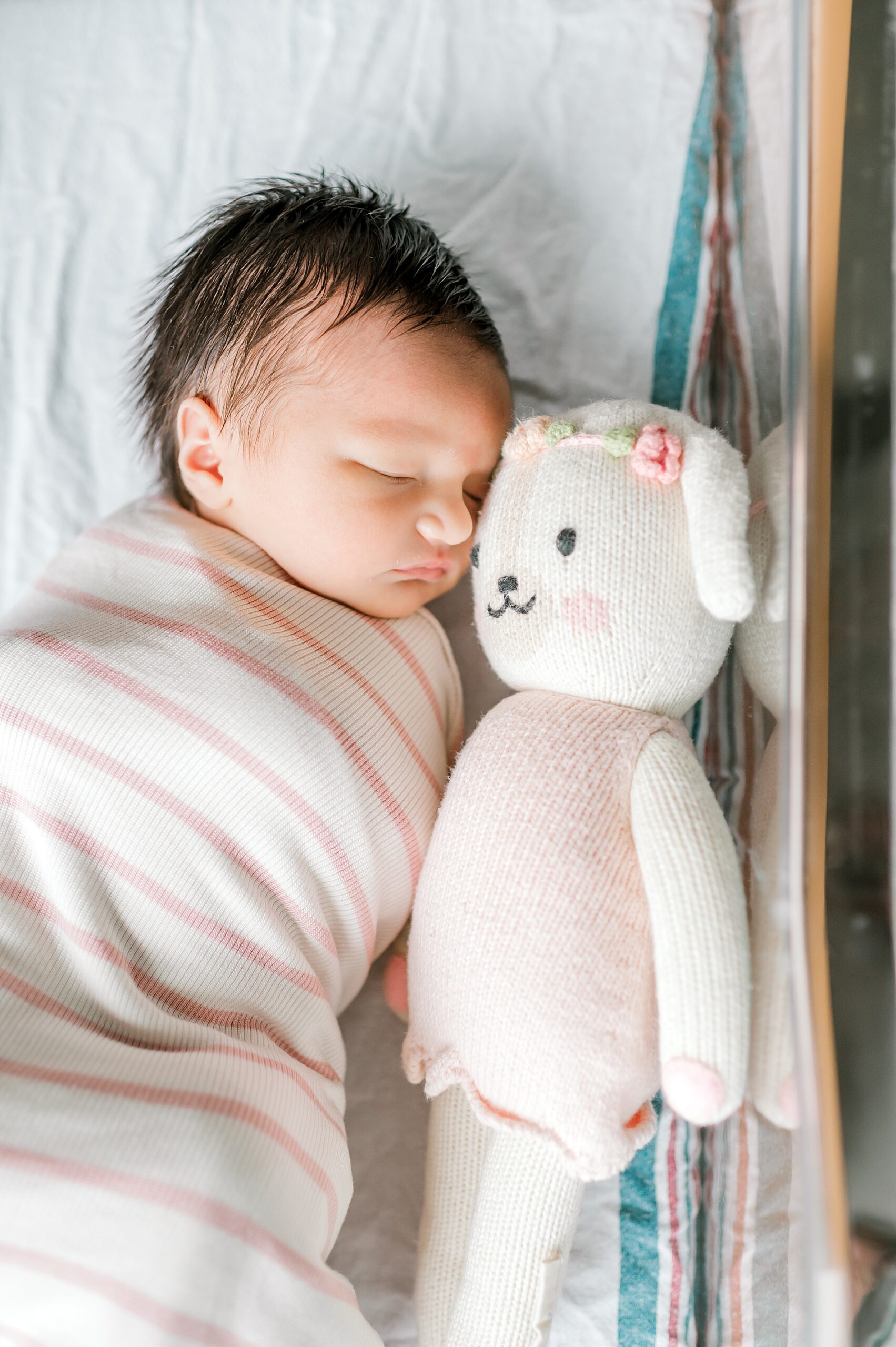 newborn girl sleeps swaddled in blanket