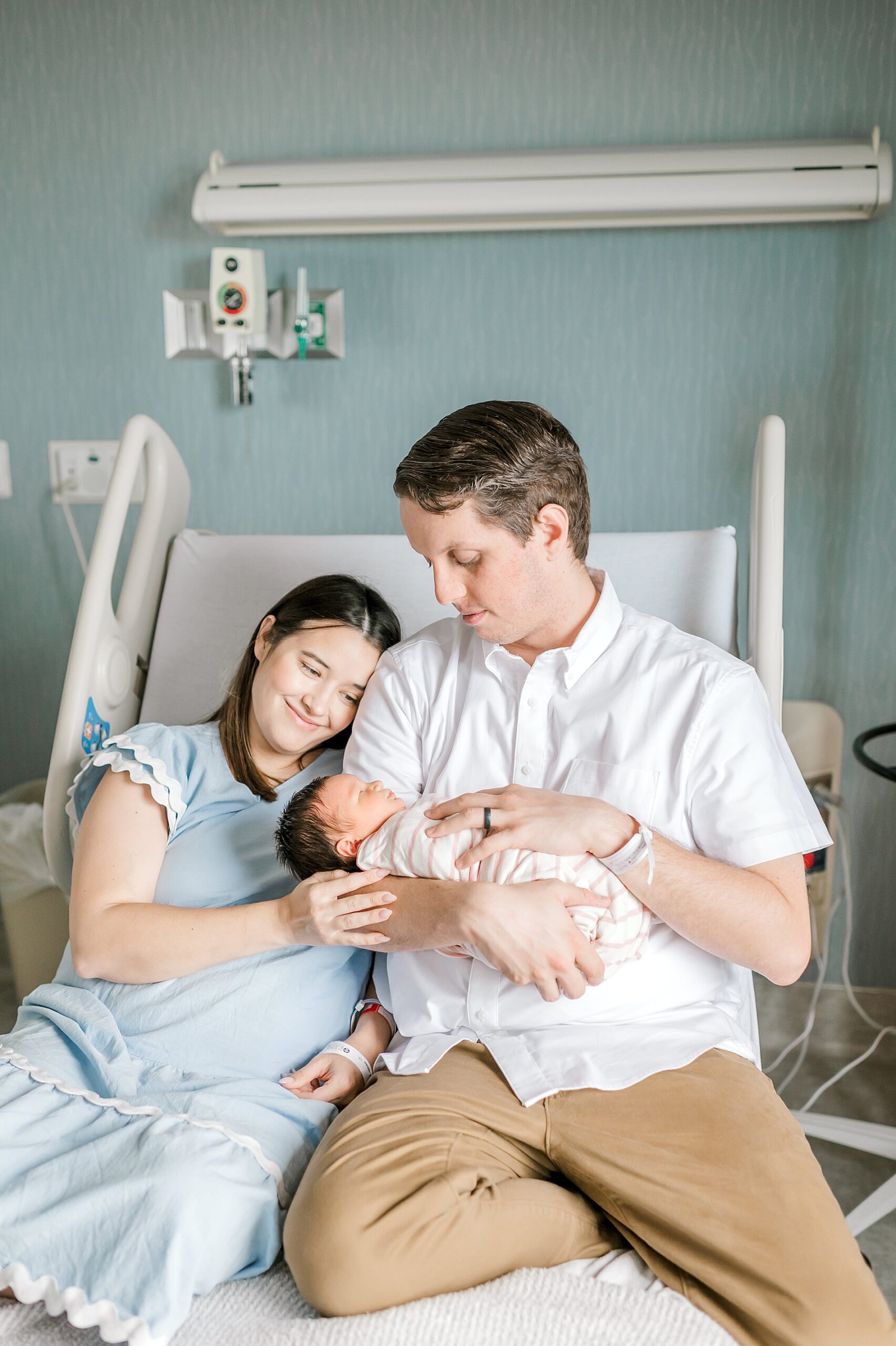 parents hold their newborn girl