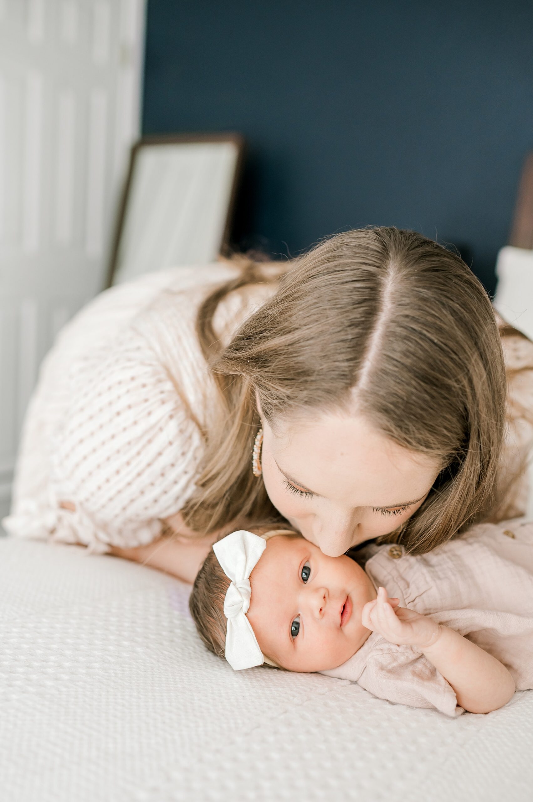 mom kisses newborn girl during lifestyle newborn session