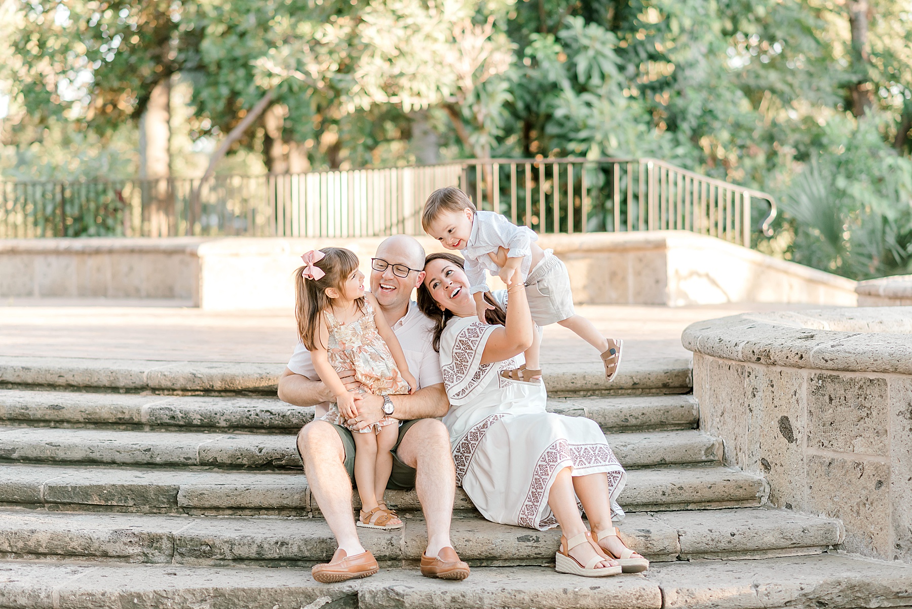 family sits on stone staircase at San Antonio Botanical Garden