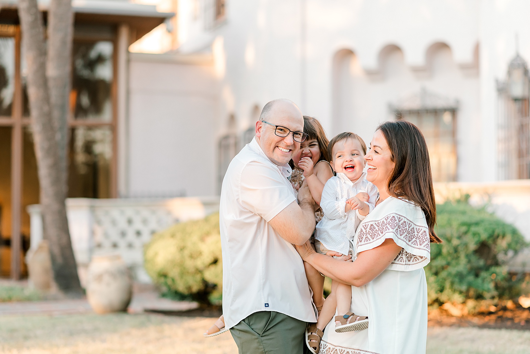 family of four laugh together during Botanical Gardens Family Session 