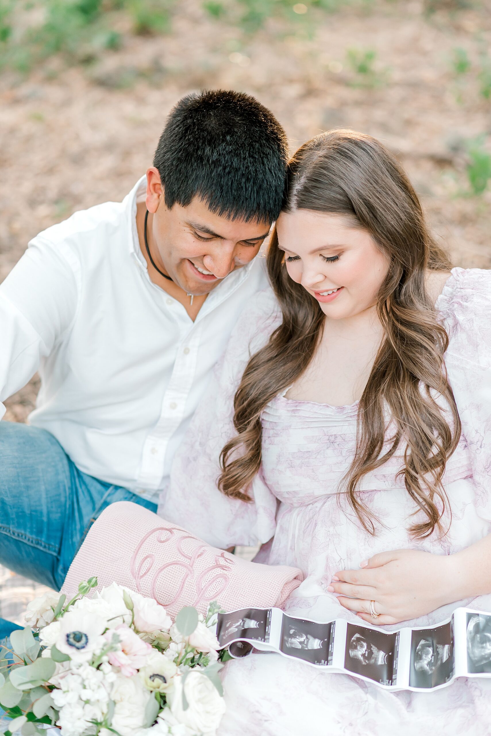 parents sit together and admire sonogram photo 