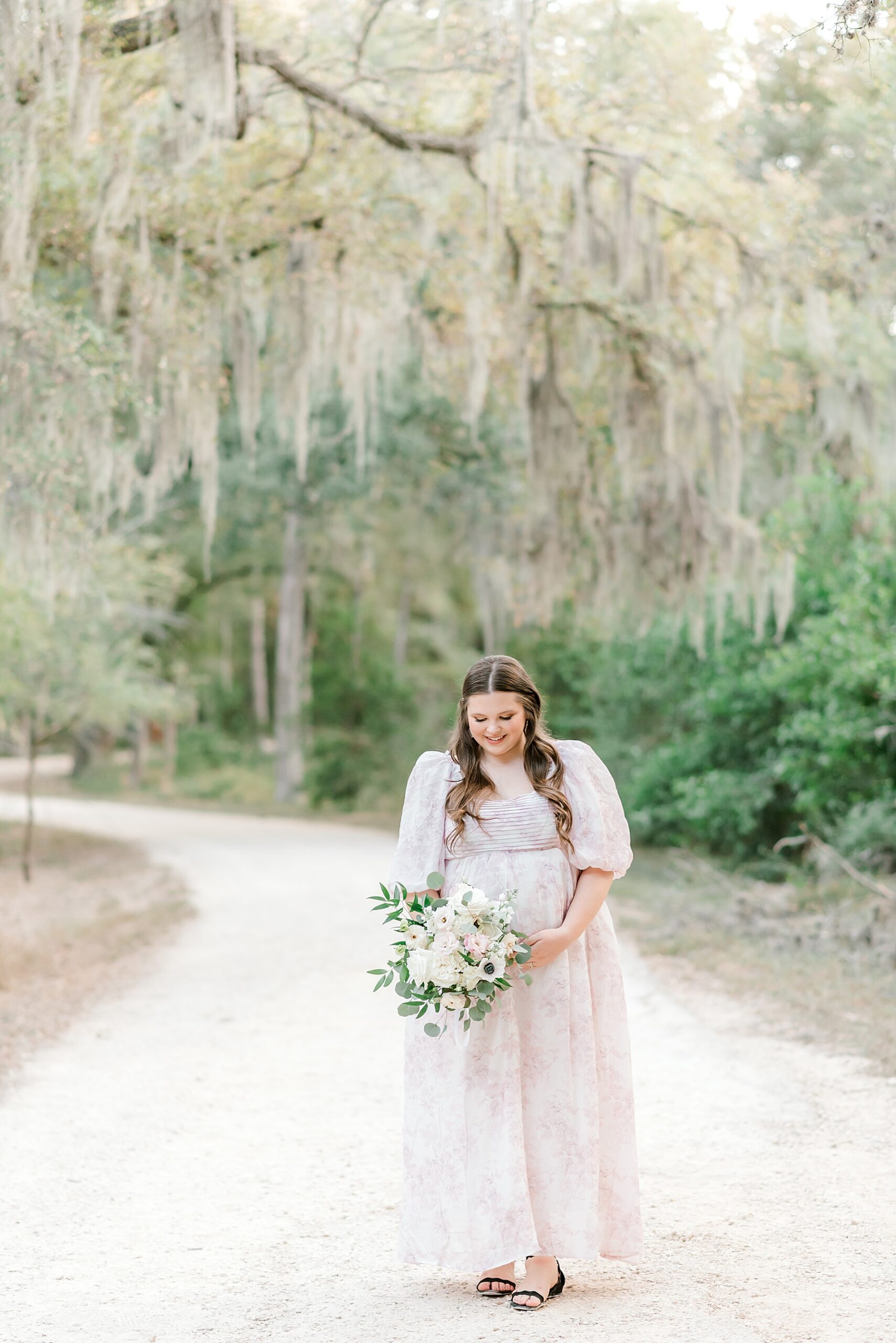 expectant mom holds flowers duting Brackenridge Park Maternity Session