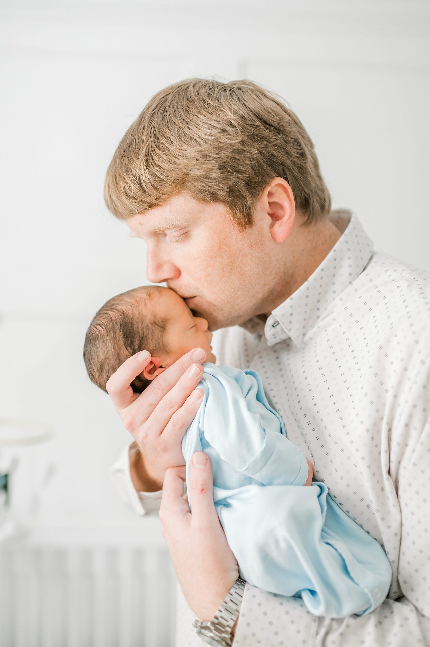 dad kisses newborn's head during Touching Lifestyle Newborn Session