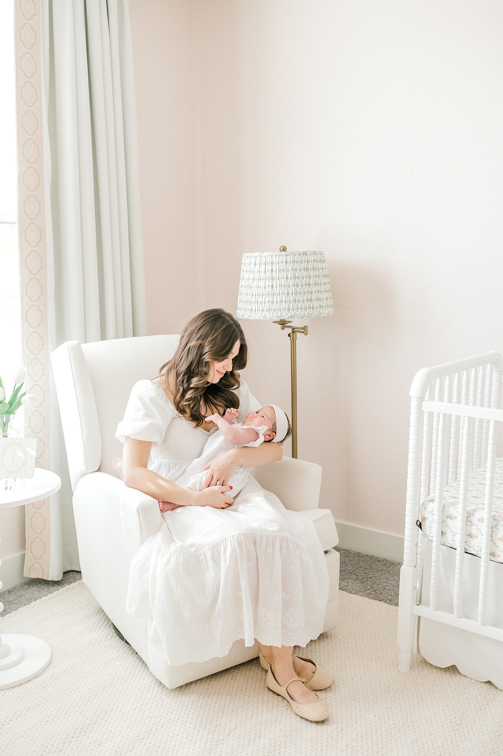 mom holds newborn in glider