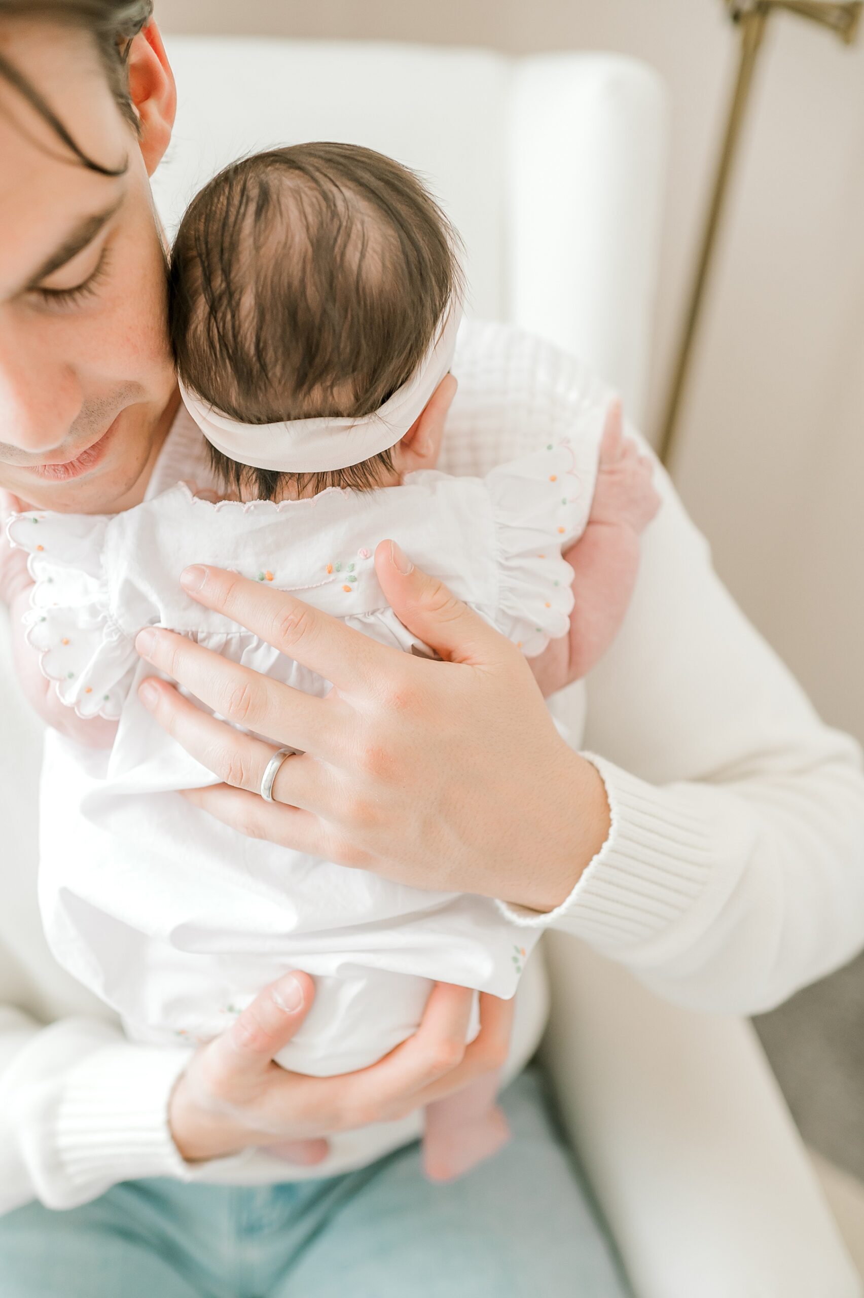 dad holds newborn girl close