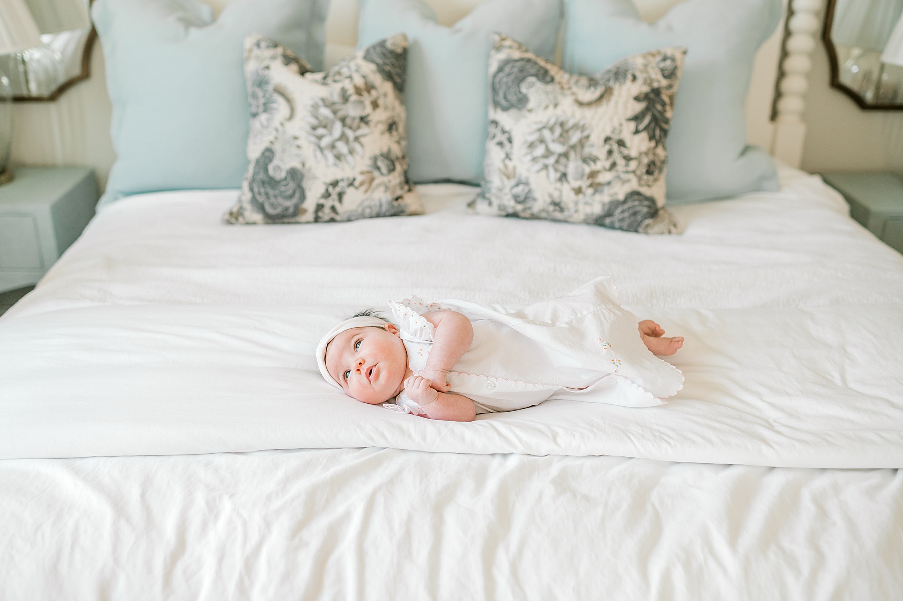 newborn girl lays on bed 