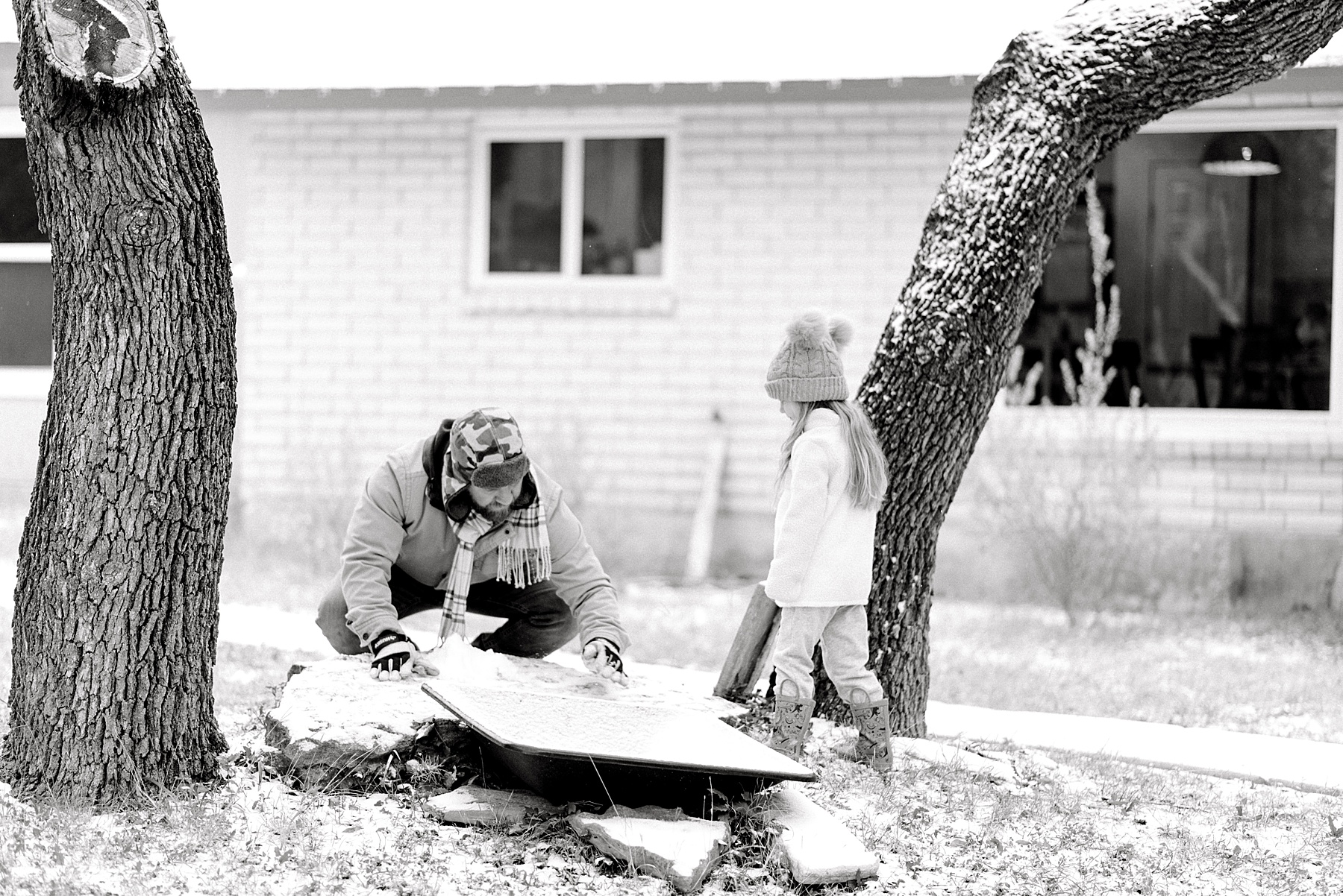 dad plays with daughter out in the Texas snow