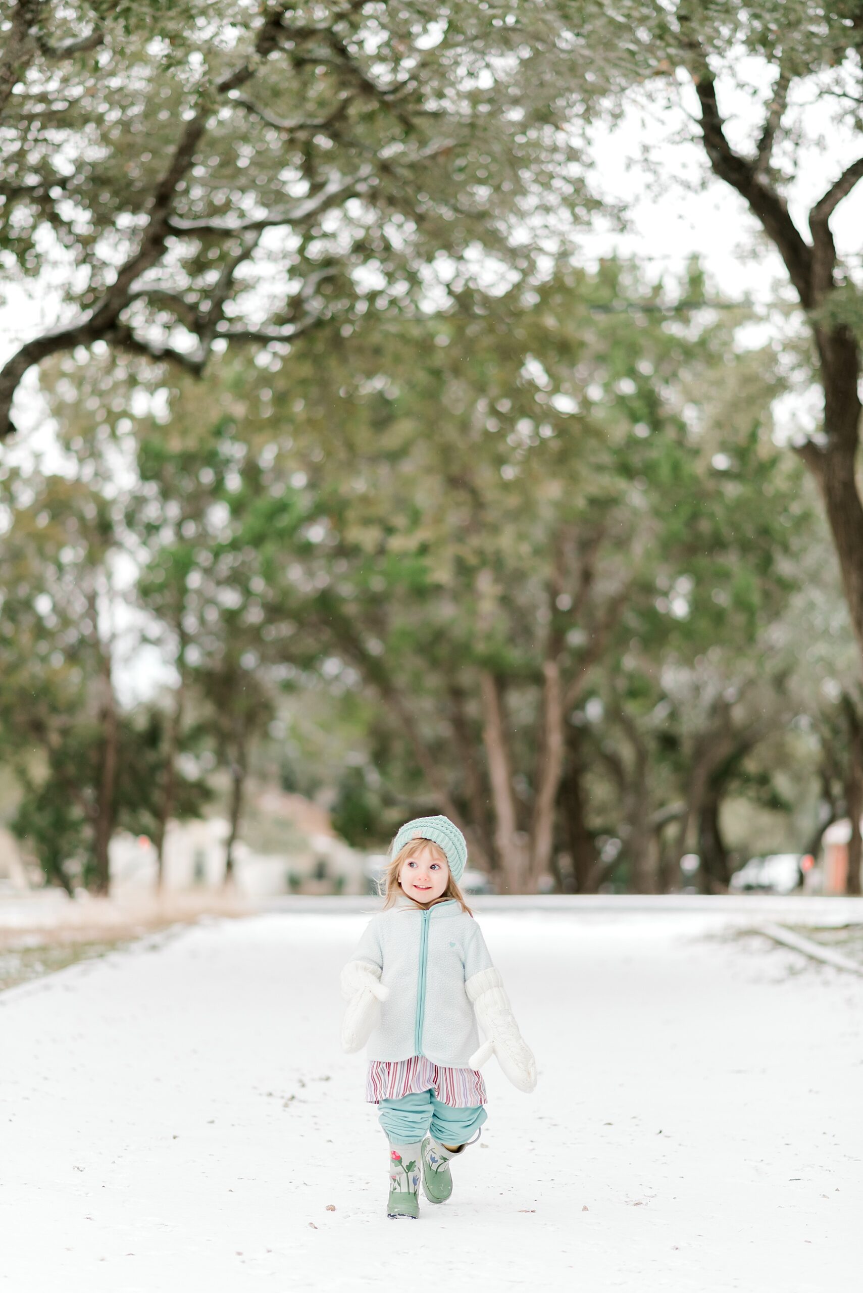 little girl walks across snow landscape in Bulverde,TX