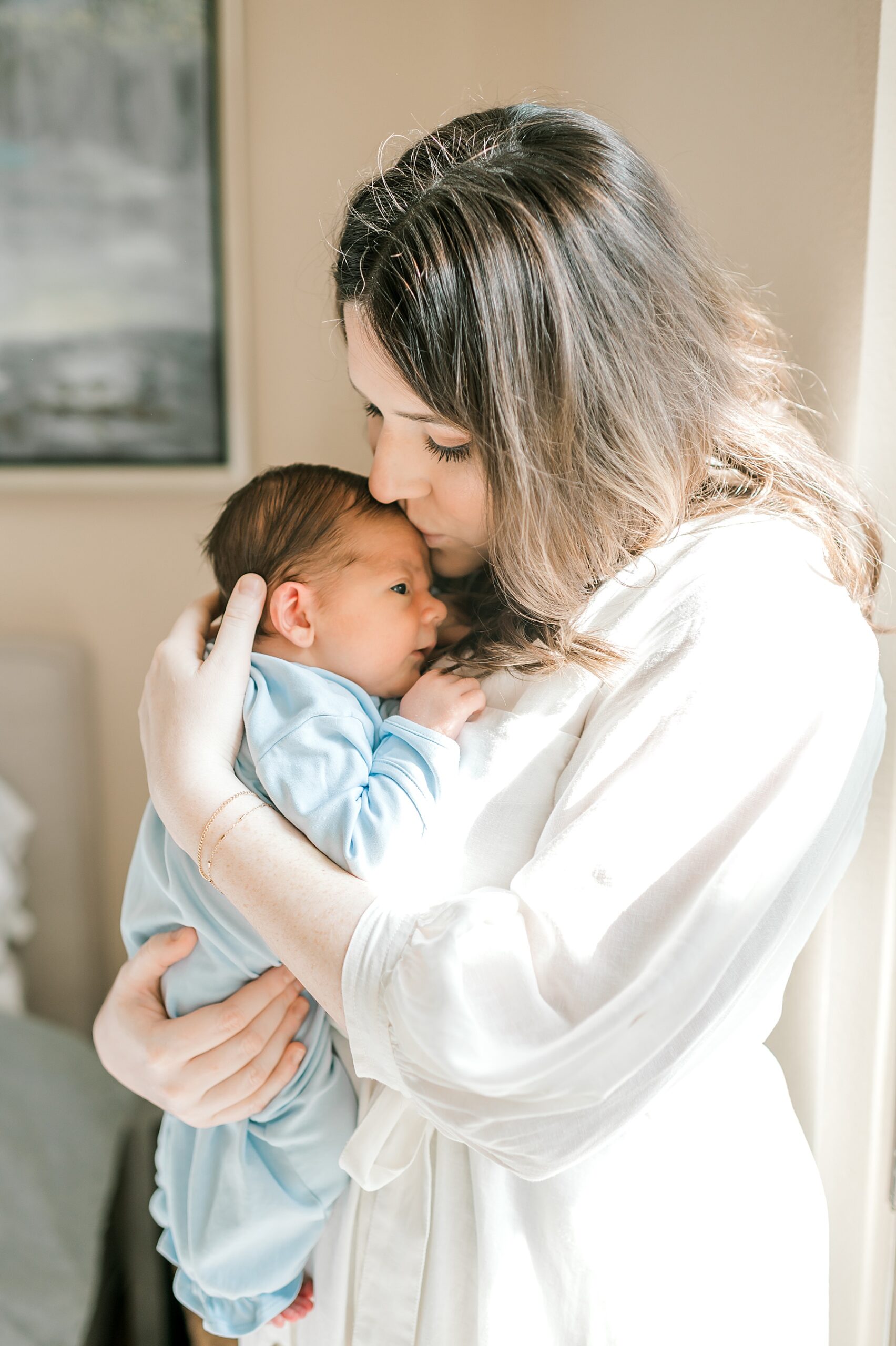 mom kisses newborn | In-Home or Studio Newborn Session: Which One is Right for You?