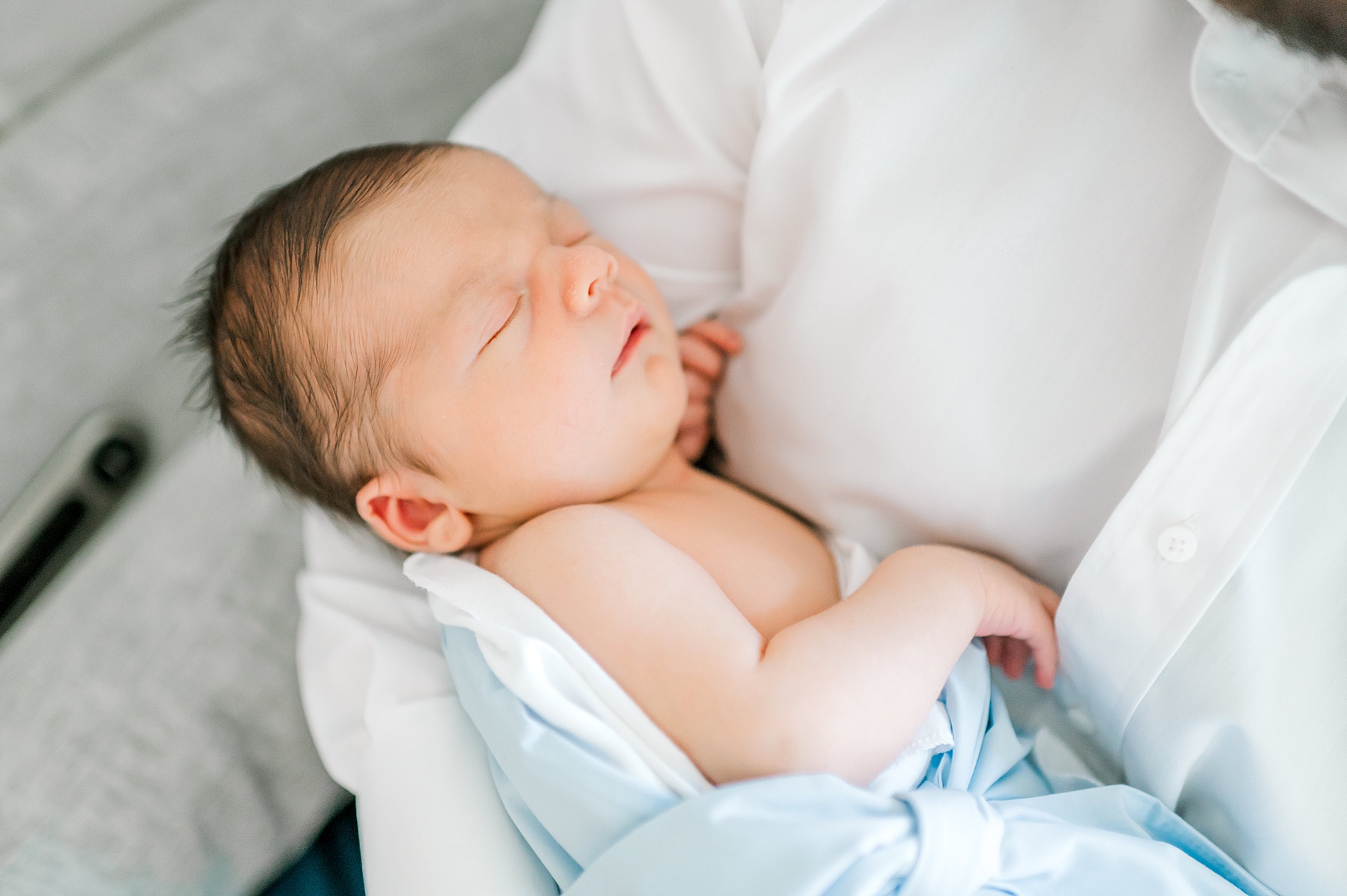 newborn sleeps in dad's arms