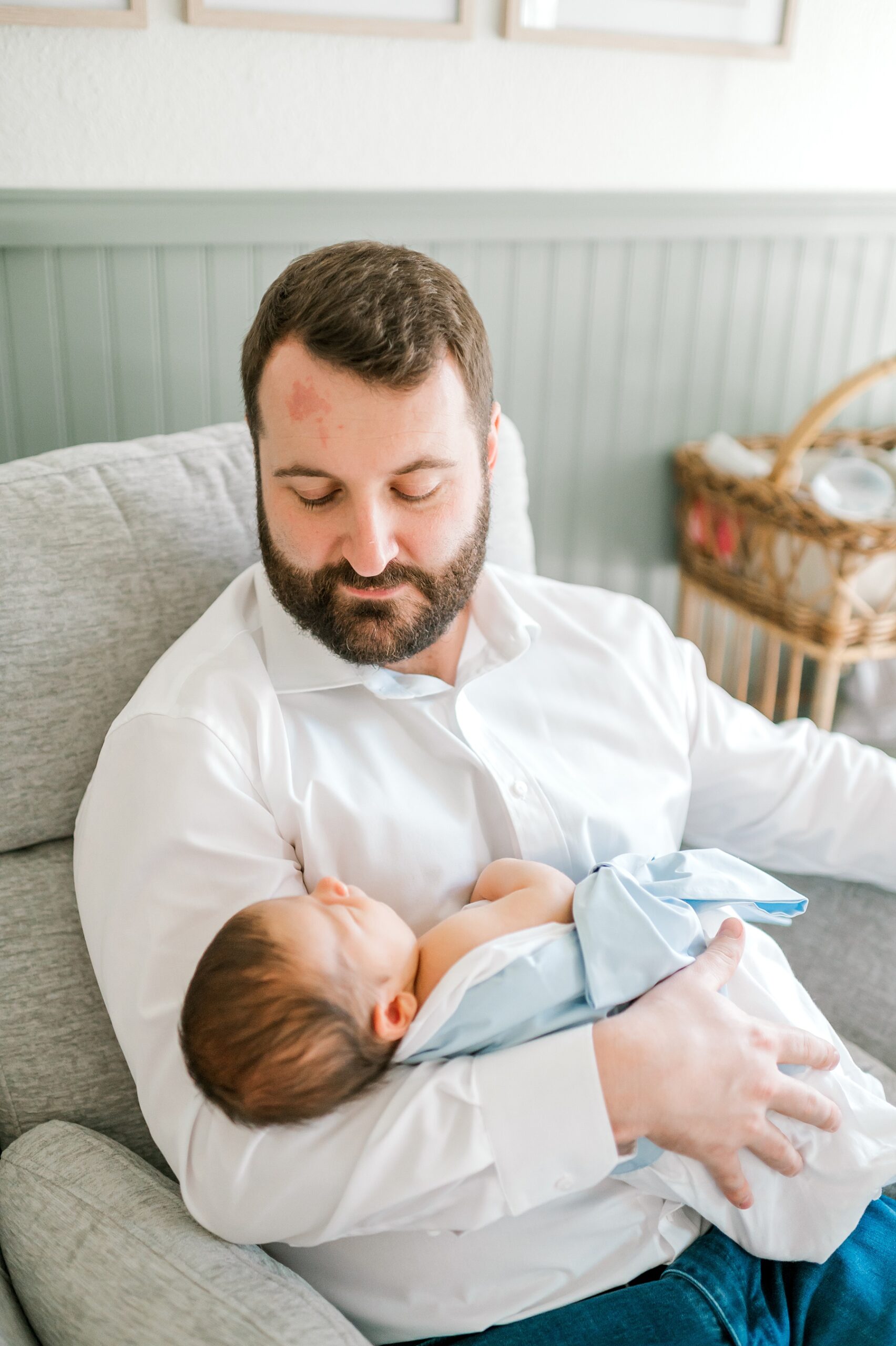 dad holds newborn during in-home lifestyle session