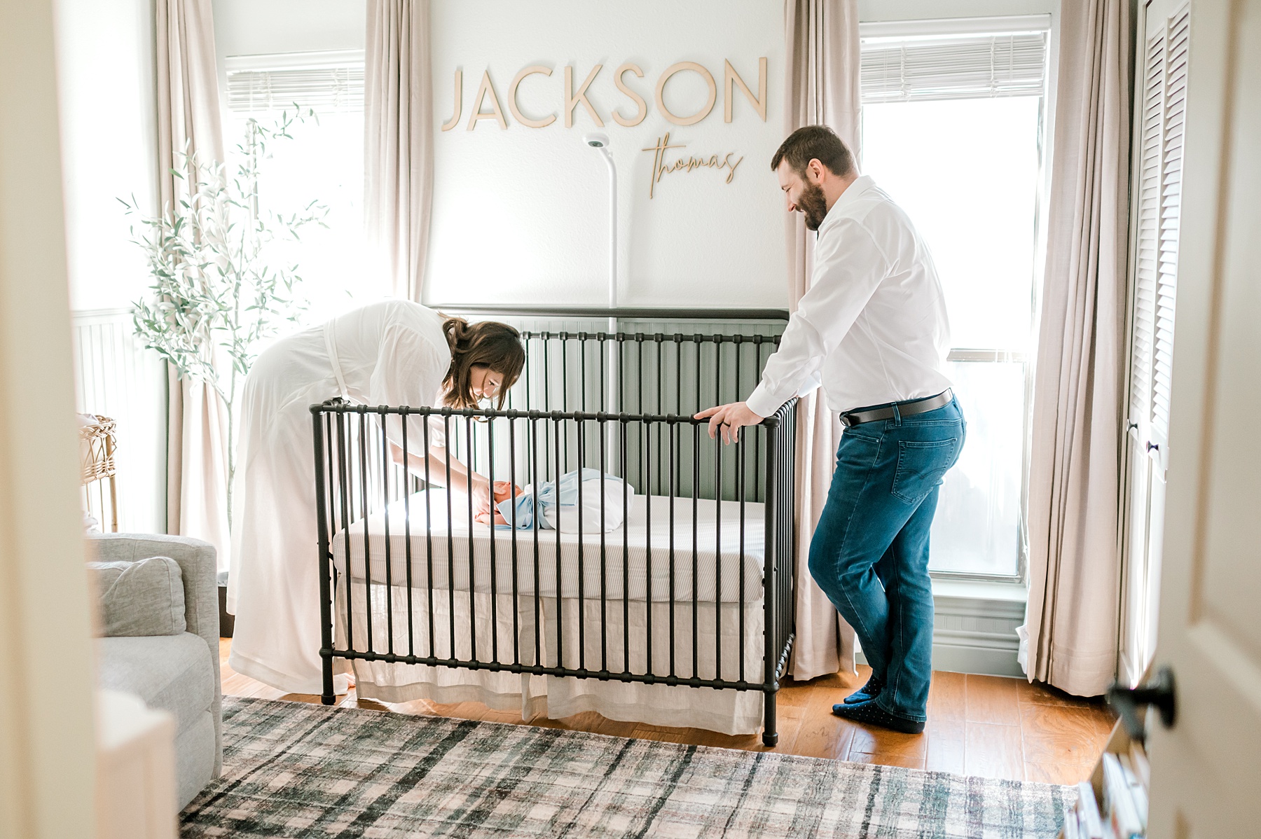 newborn sleeps in crib with parents nearby