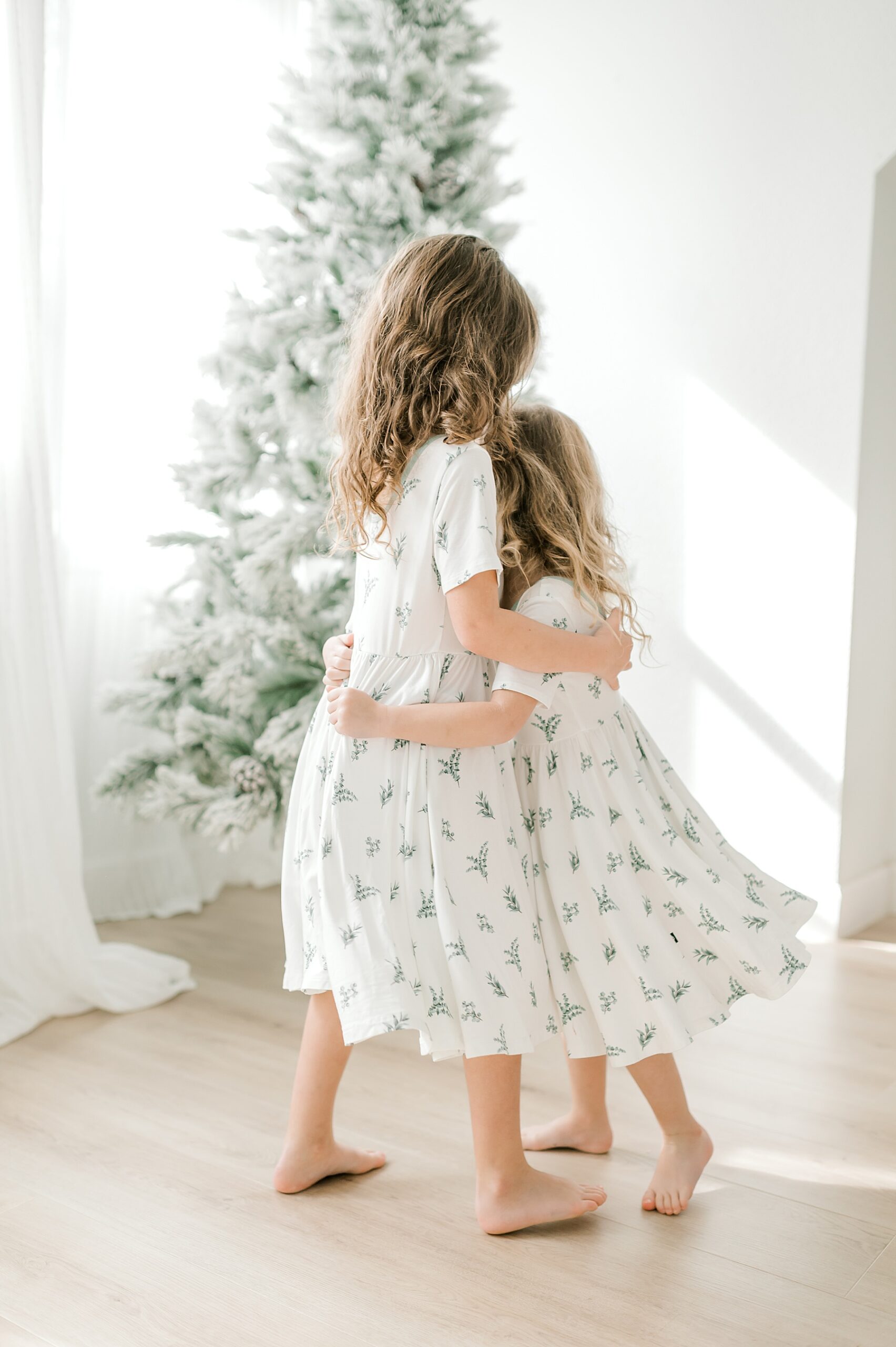 sisters in matching dresses hug each other 