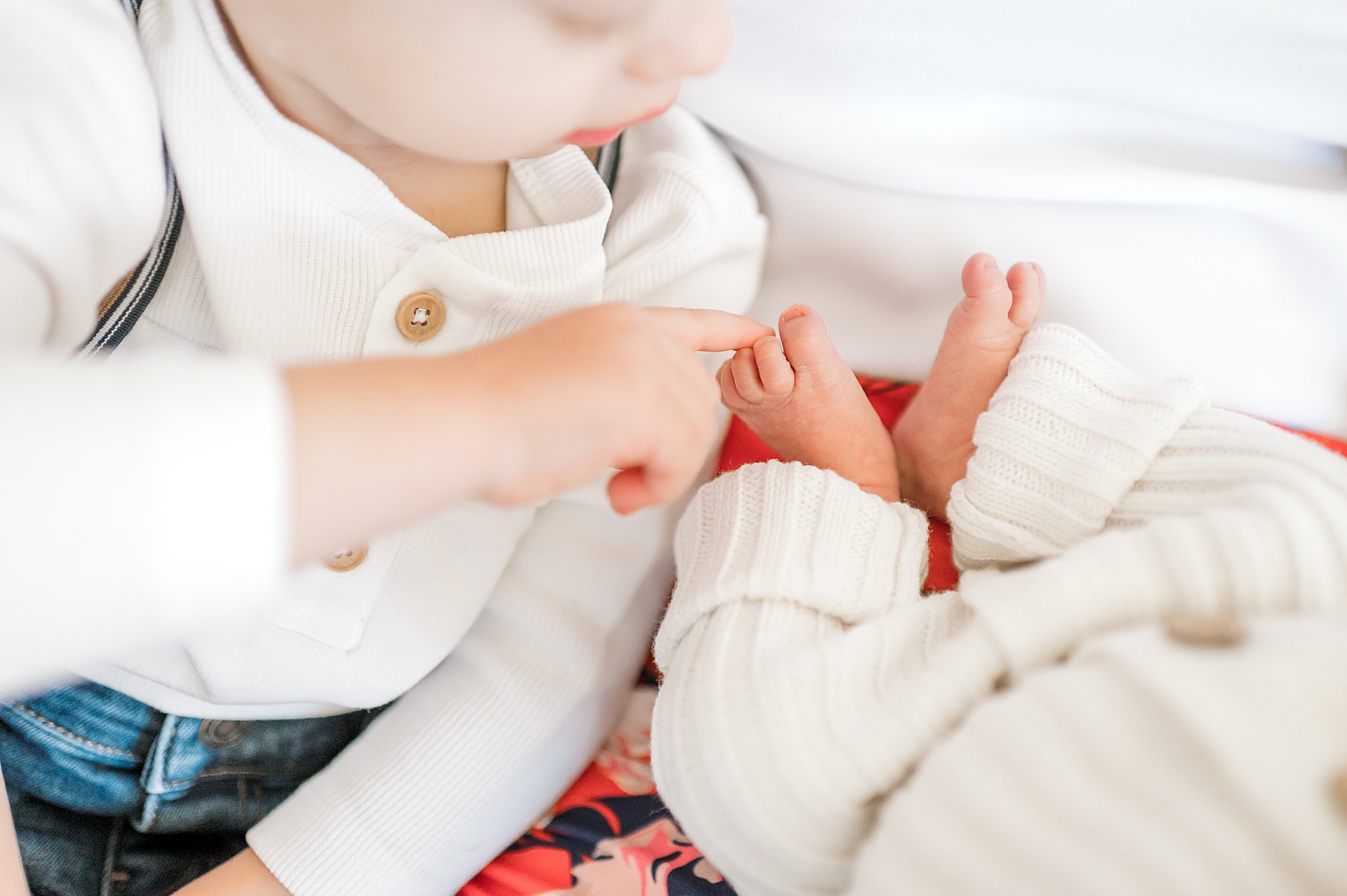 older brother touches newborn's tiny toes | Lifestyle Newborn Photography 