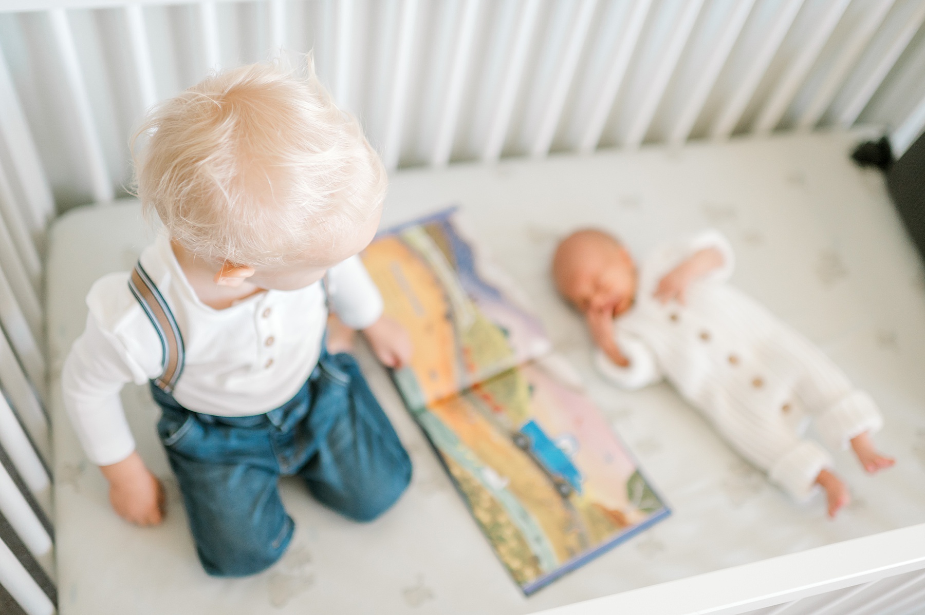 big brother reads to baby brother during Candid In-Home Newborn Session | Lifestyle Newborn Photography