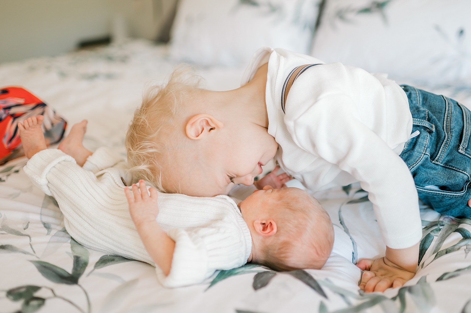 big brother leans down to kiss baby brother