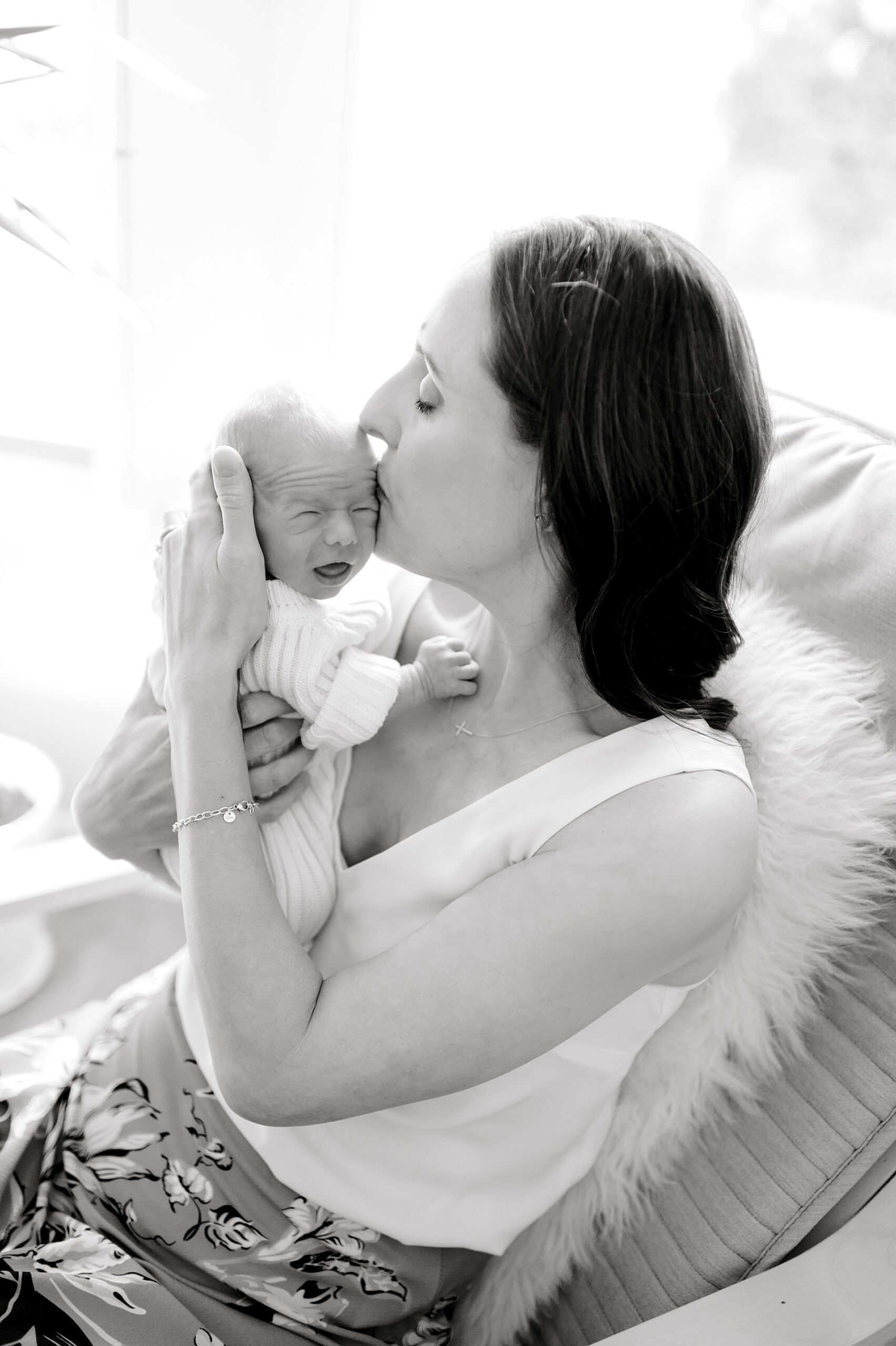 timeless photo of mom kissing newborn baby