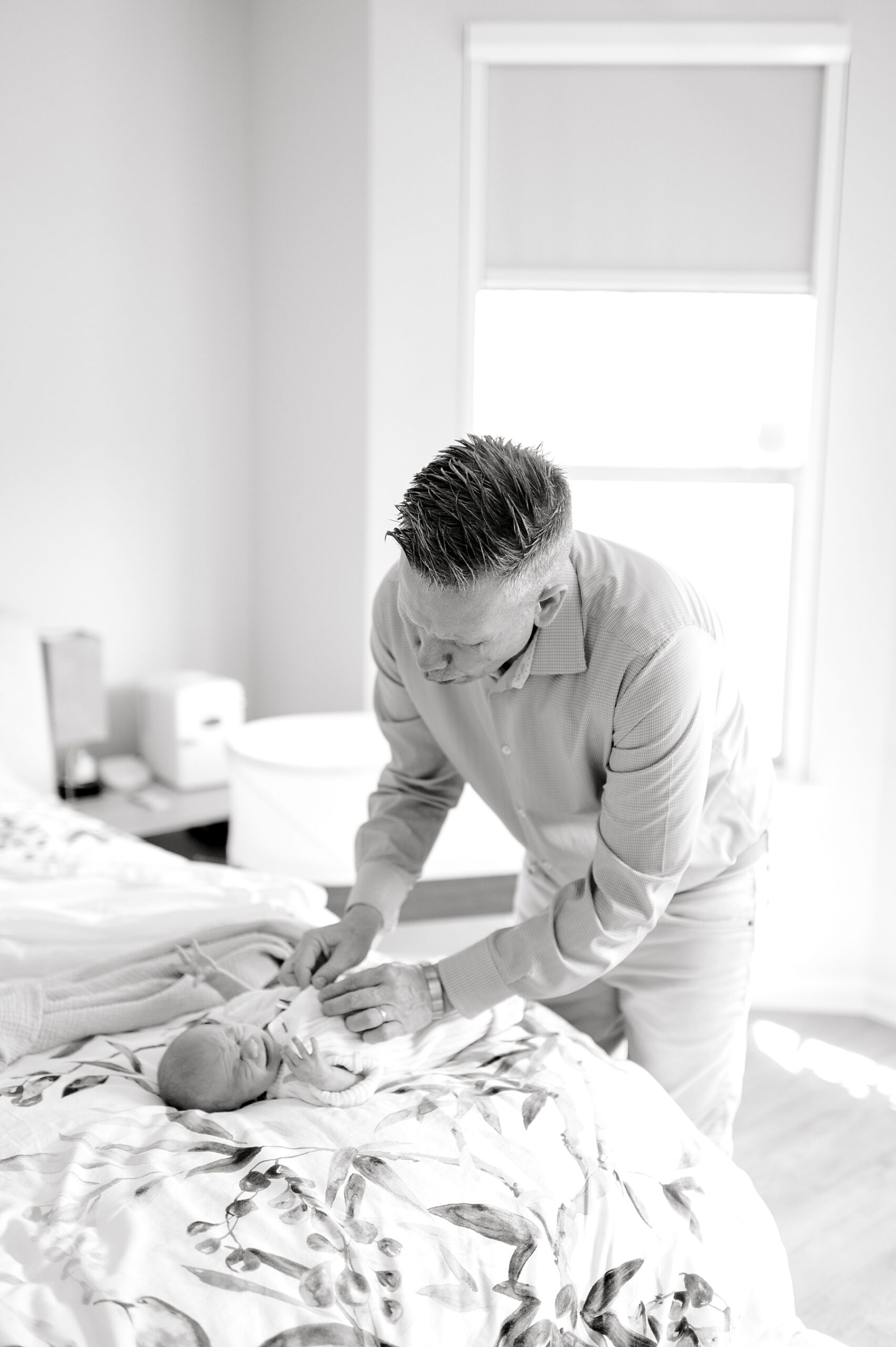 dad wraps newborn in blanket | Lifestyle Newborn Photography