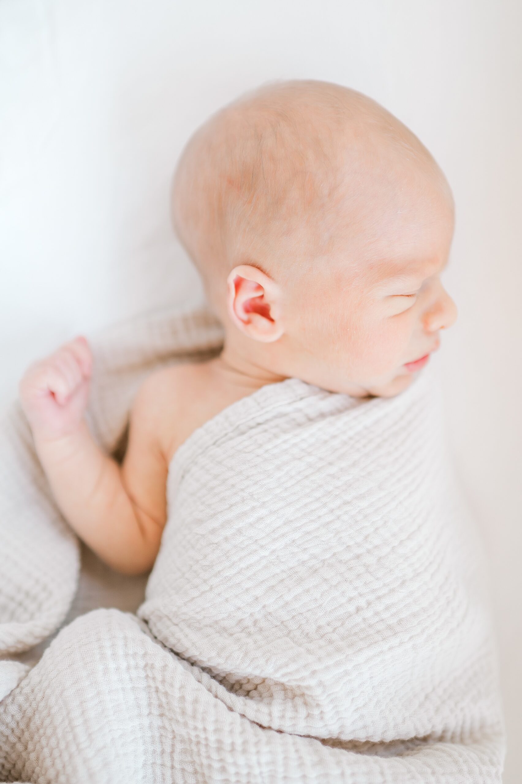 Newborn boy wrapped in beige blanket