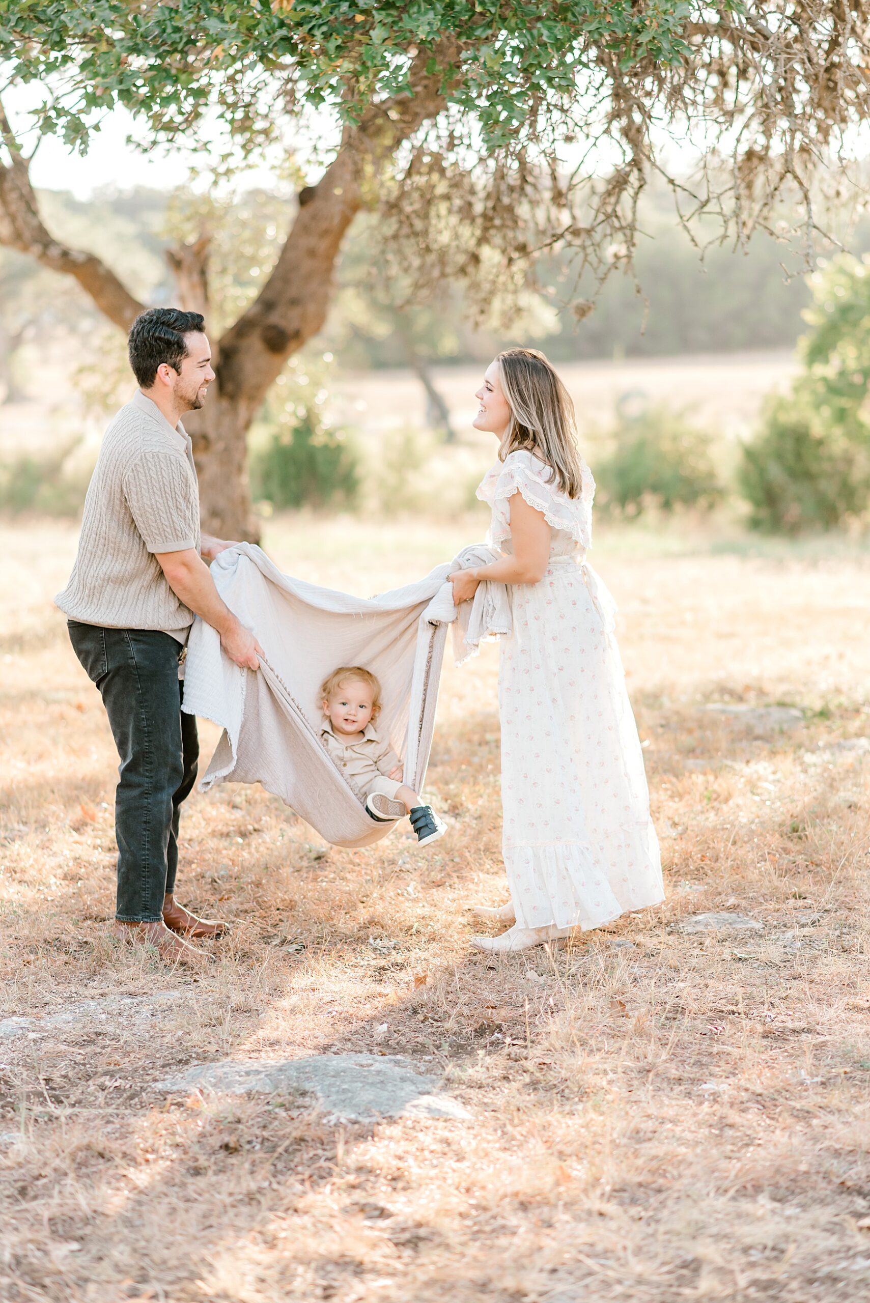 parents swing son in blanket 