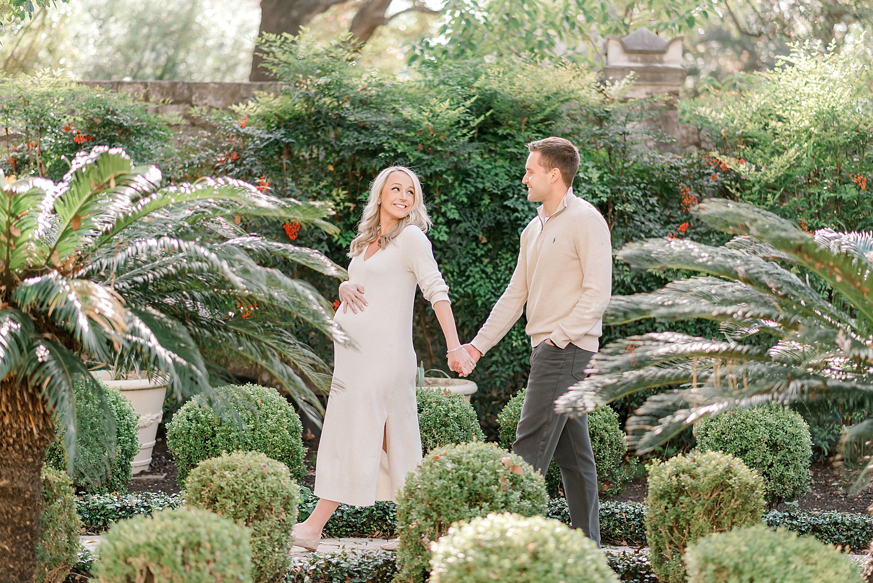 couple hold hands as they walk through a garden in Downtown San Antonio