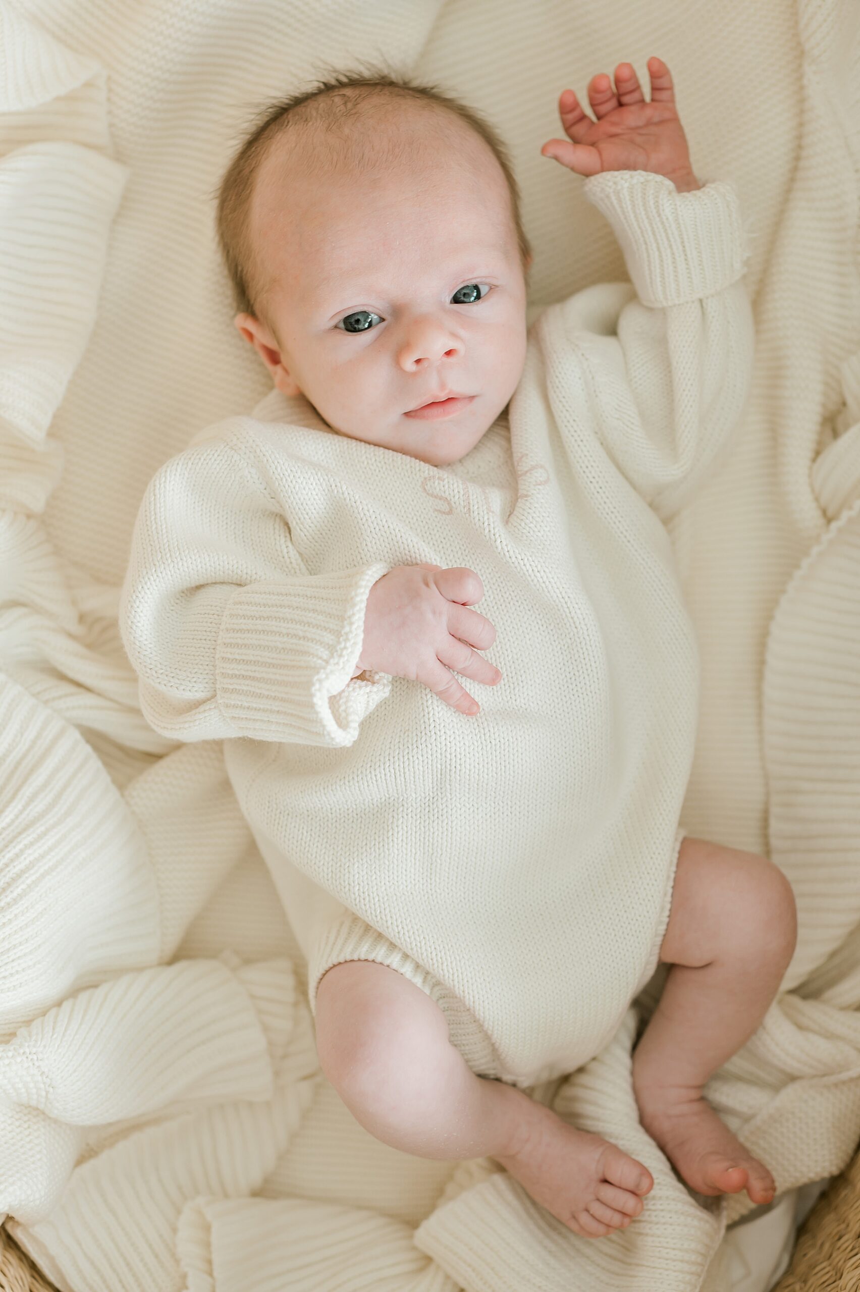 baby boy in cream personalized sweater during Cozy Winter Newborn Session  