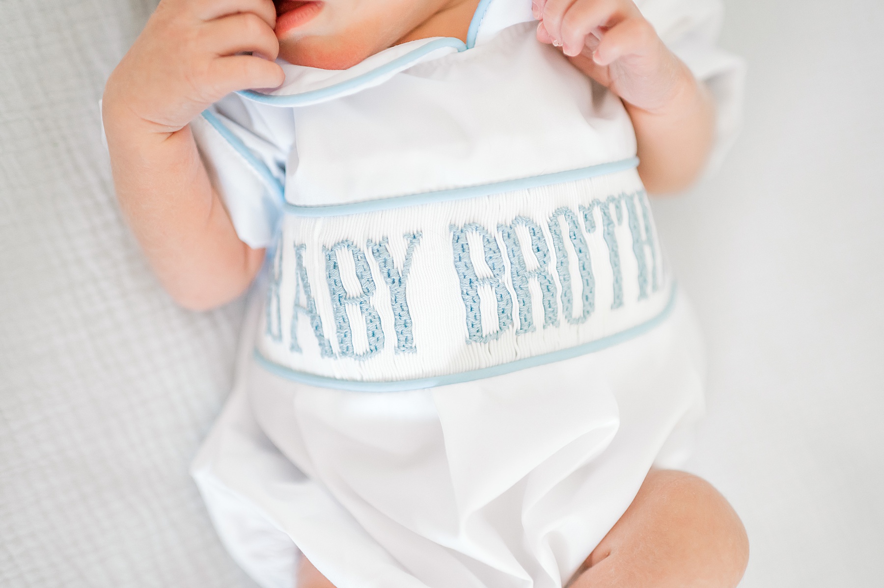 newborn in baby brother onsie