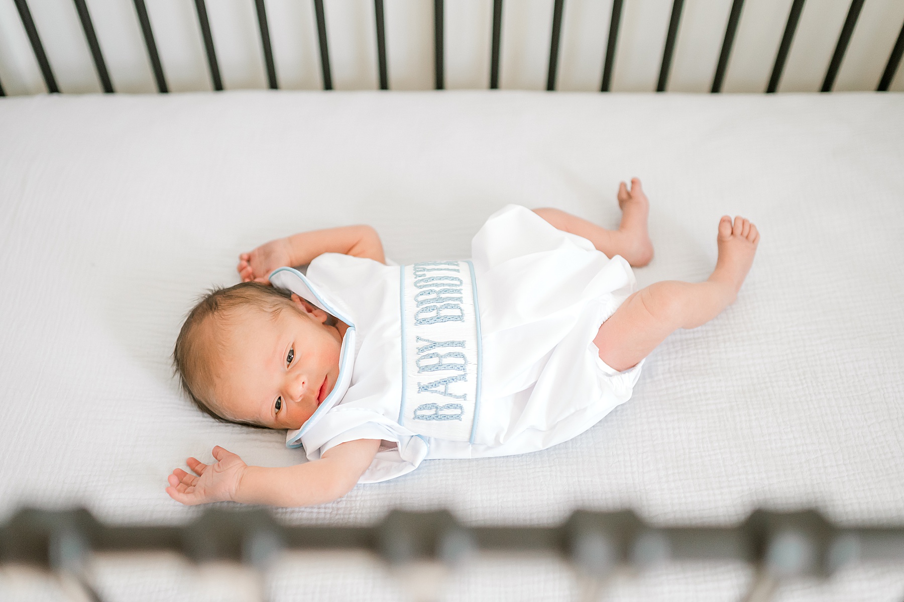 newborn in baby brother onsie 