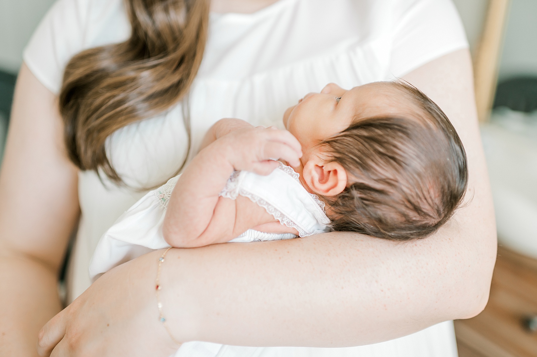 mom holds newborn girl in arms
