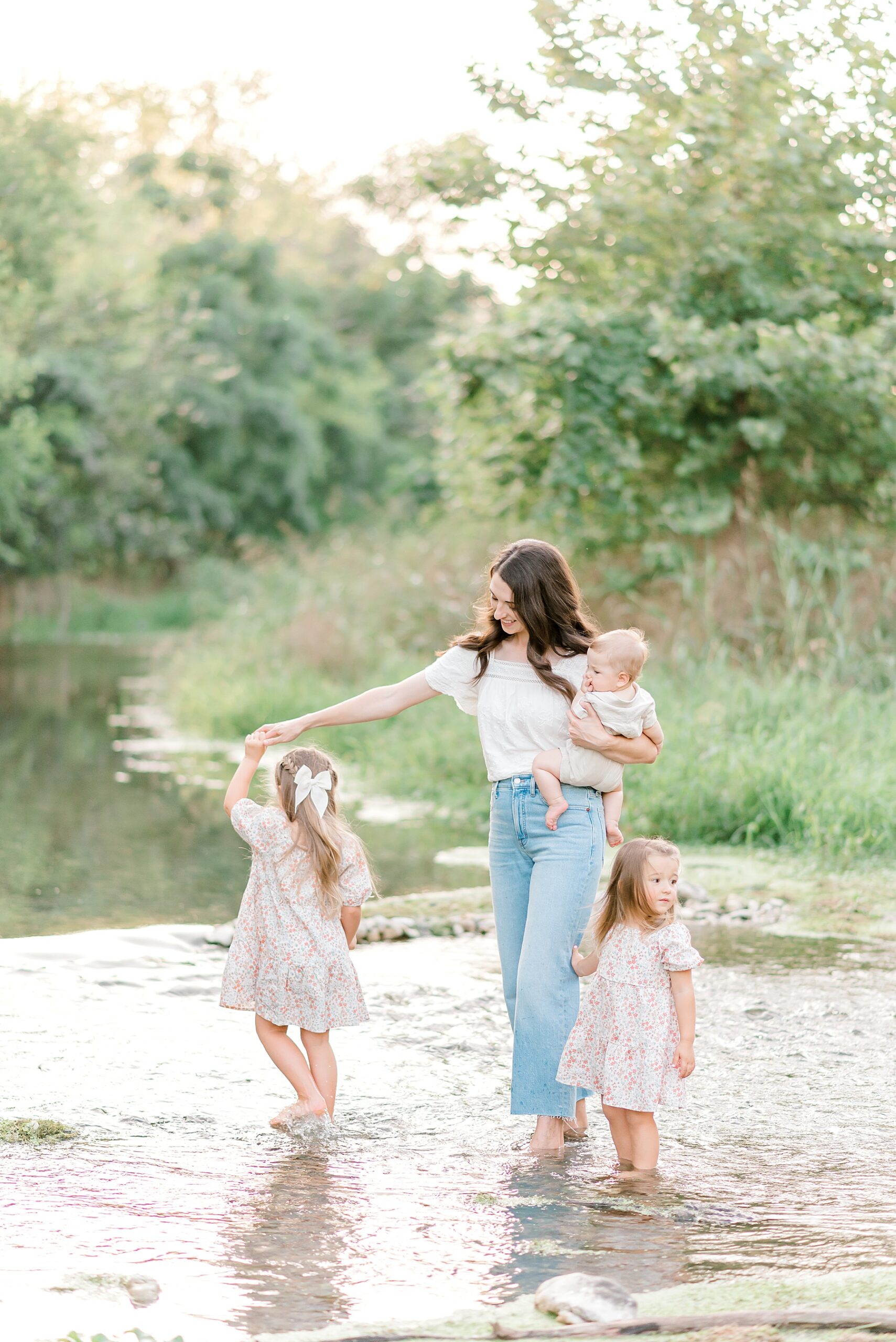 mom plays with her three kids in the river