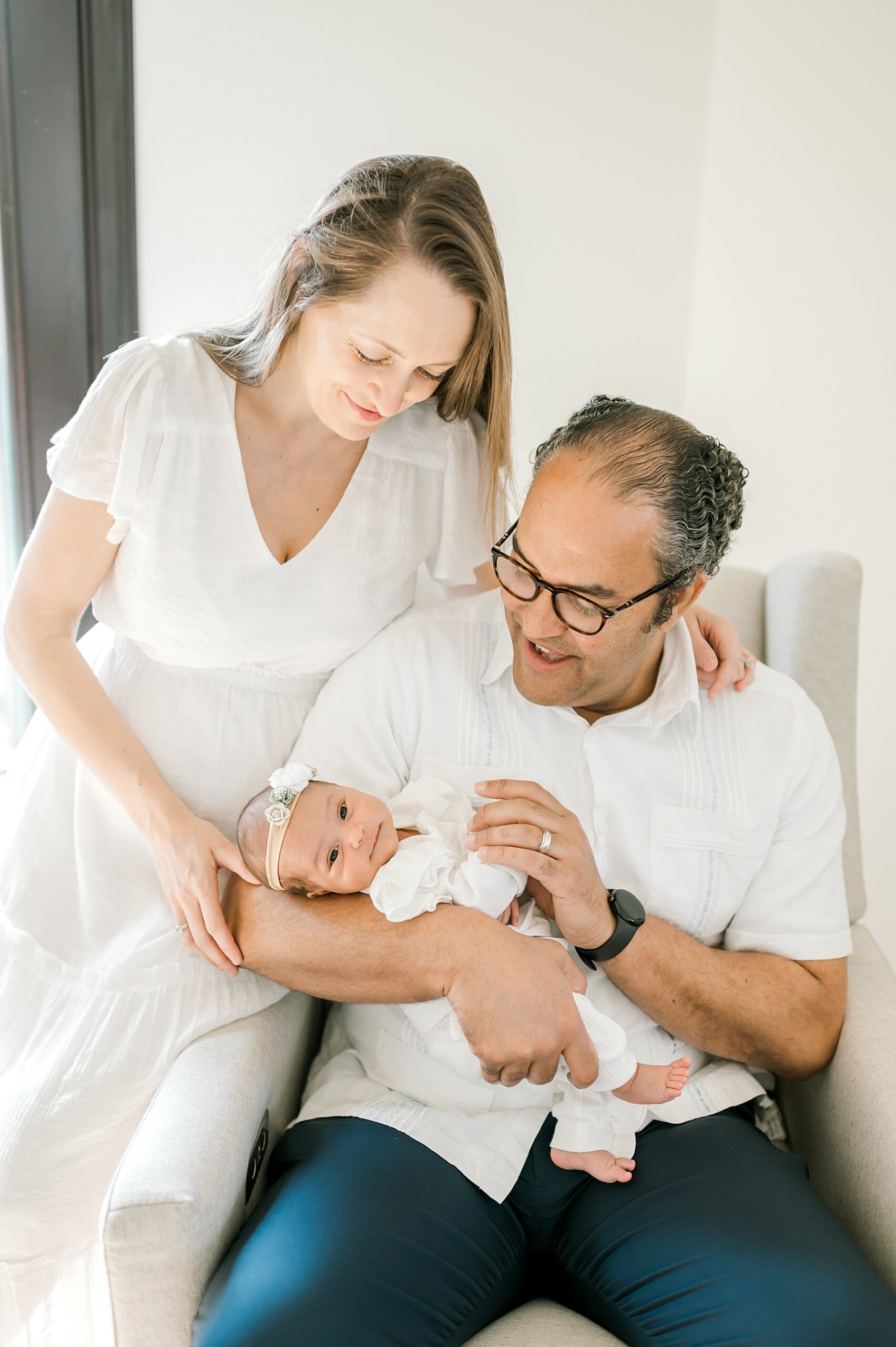 parents lovingly admire newborn girl during Simple and Sweet Newborn Session