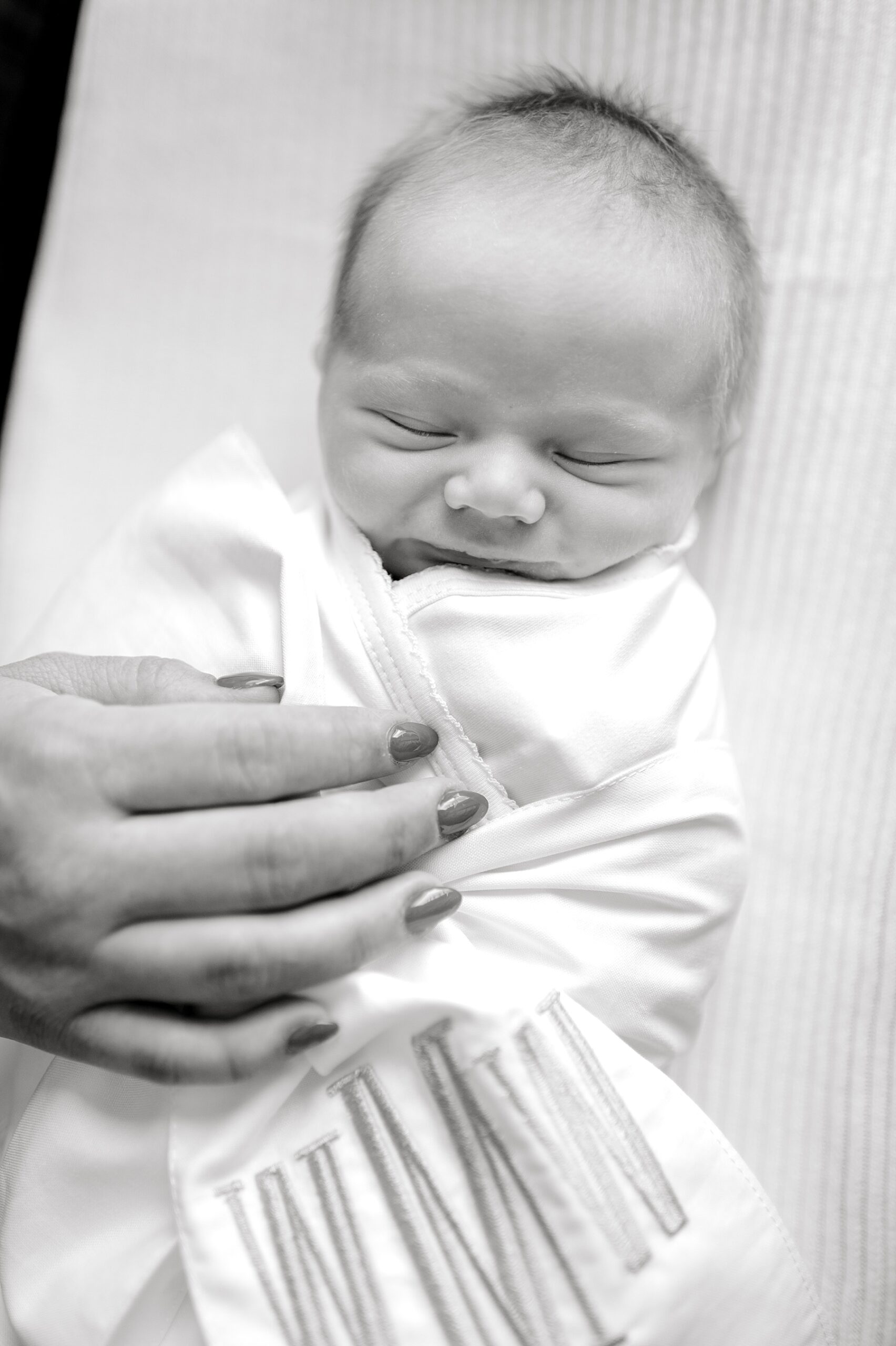 newborn sleeps in monogramed blanket