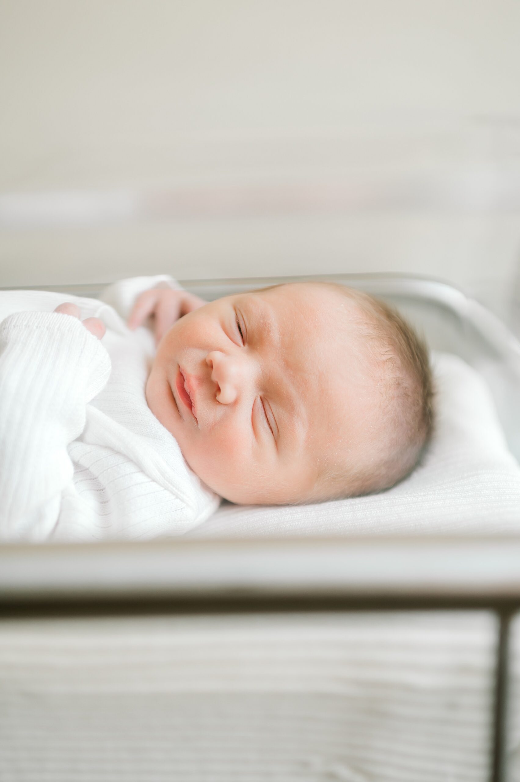 newborn sleeps in hospital bassinet