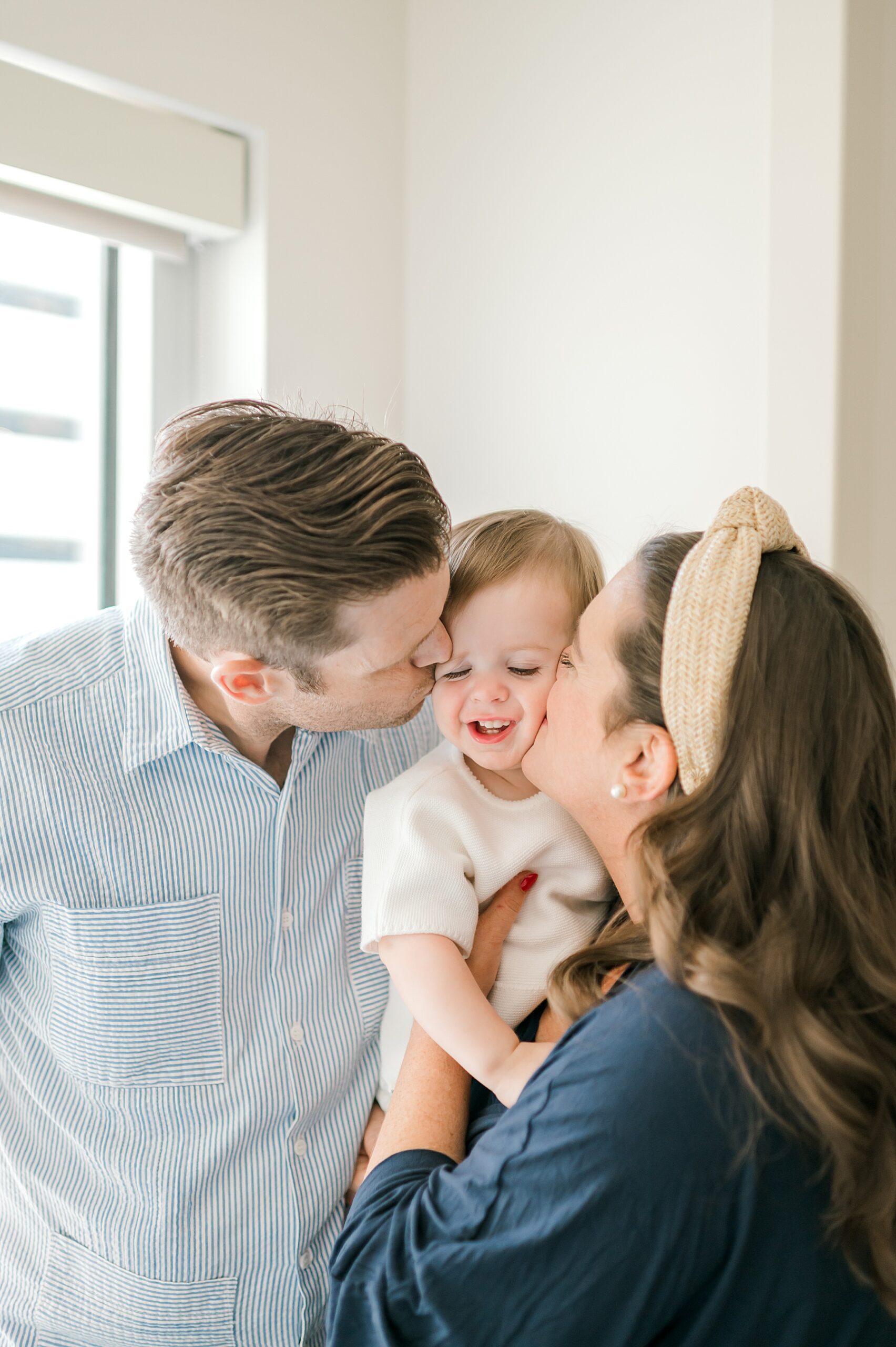 parents kiss their son