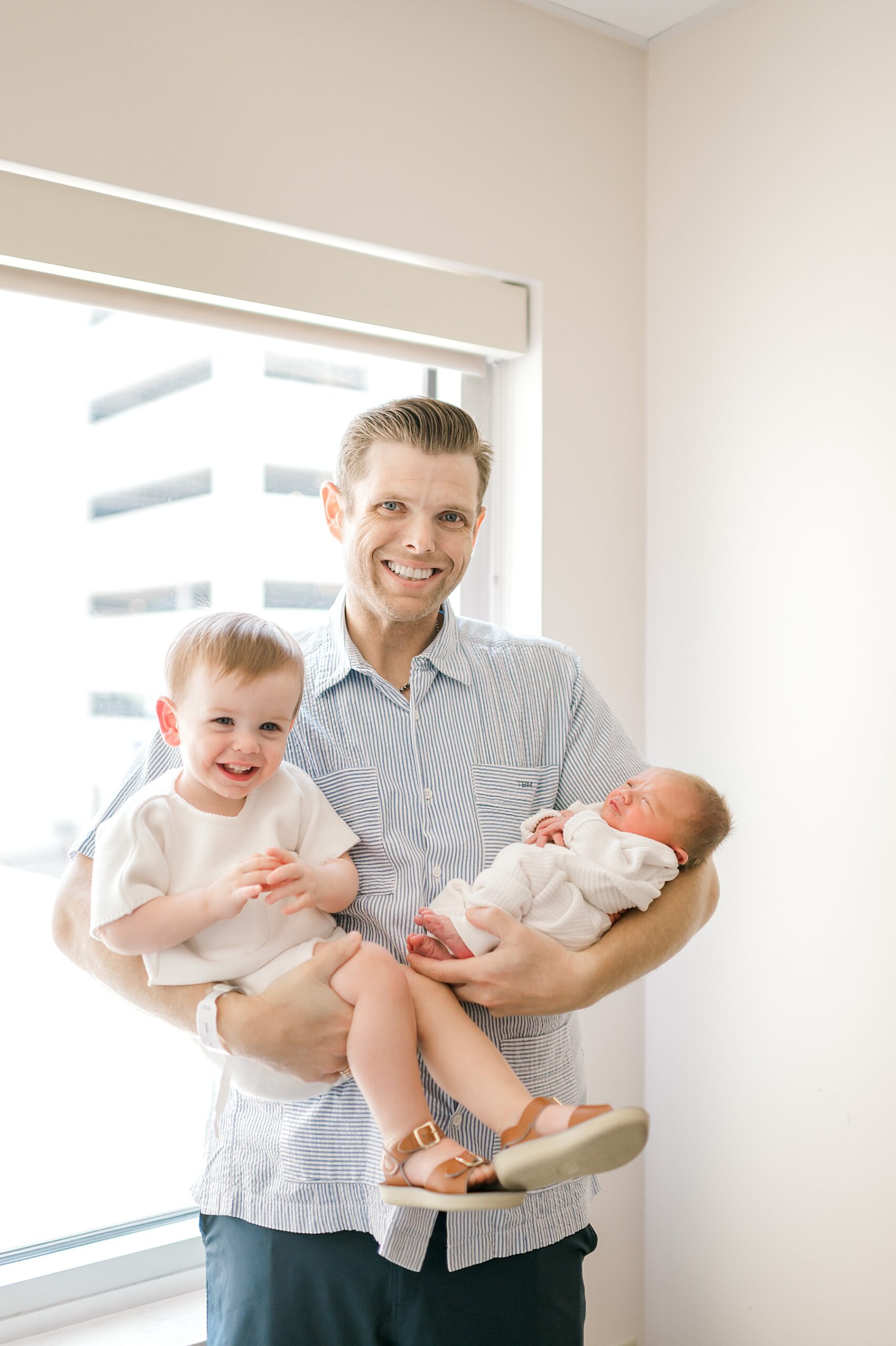 dad holds his two boys in arms