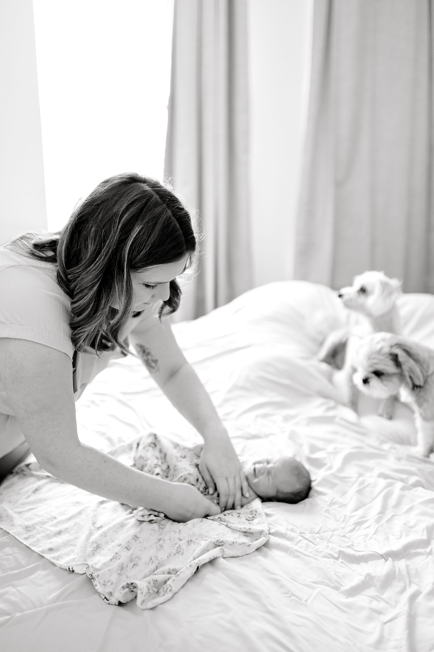 mom wraps newborn in blanket
